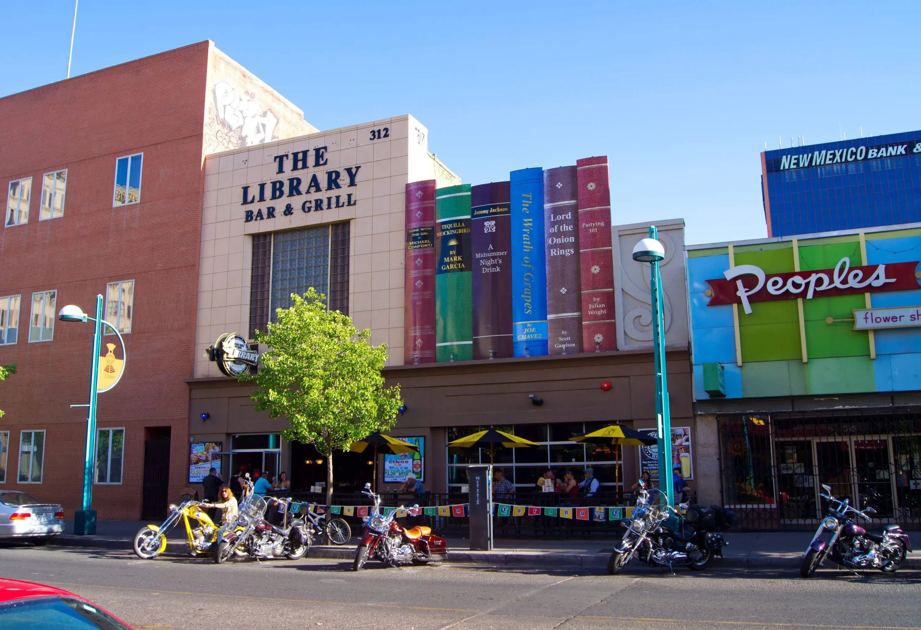 A modern-day bar and grill on Historic Route 66 (Central Avenue) in downtown Albuquerque, New Mexico. The mock book titles are food and drink based plays on real book titles. Albuquerque is an attraction for Route 66 tourists in New Mexico.