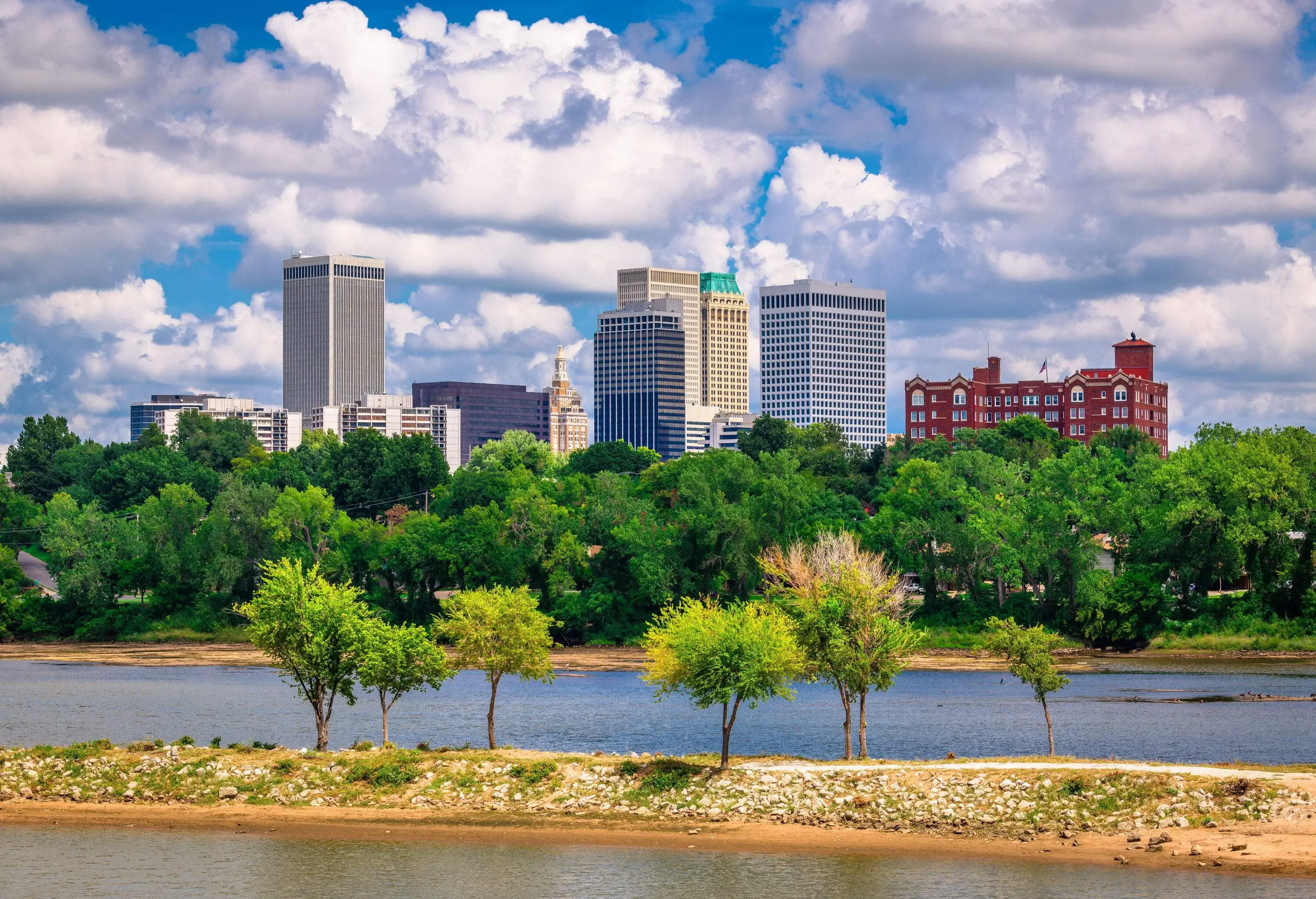 A river across a forested landscape with distant views of the city skyline.