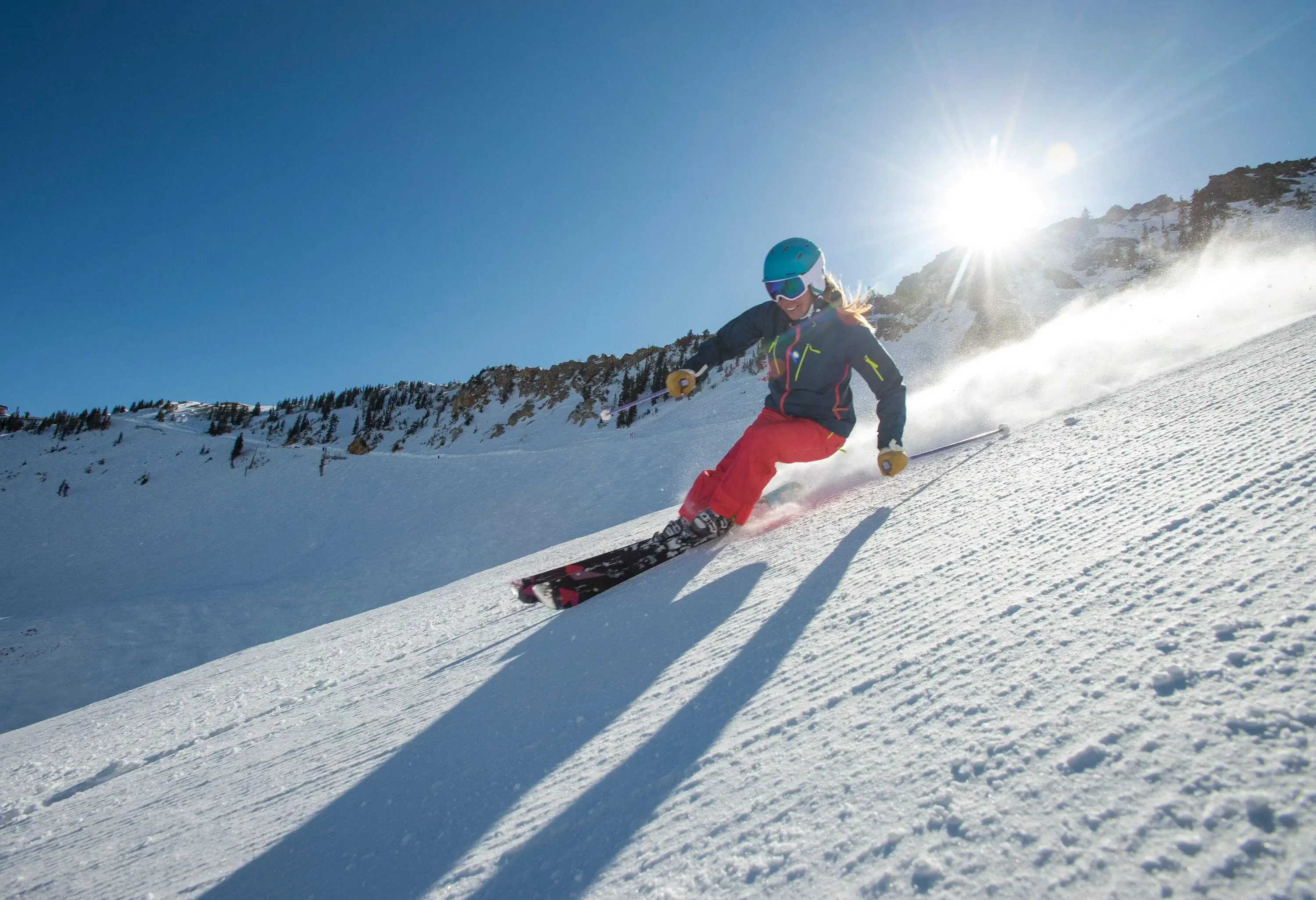 A woman skis through sloppy powder snowland in the mountains.