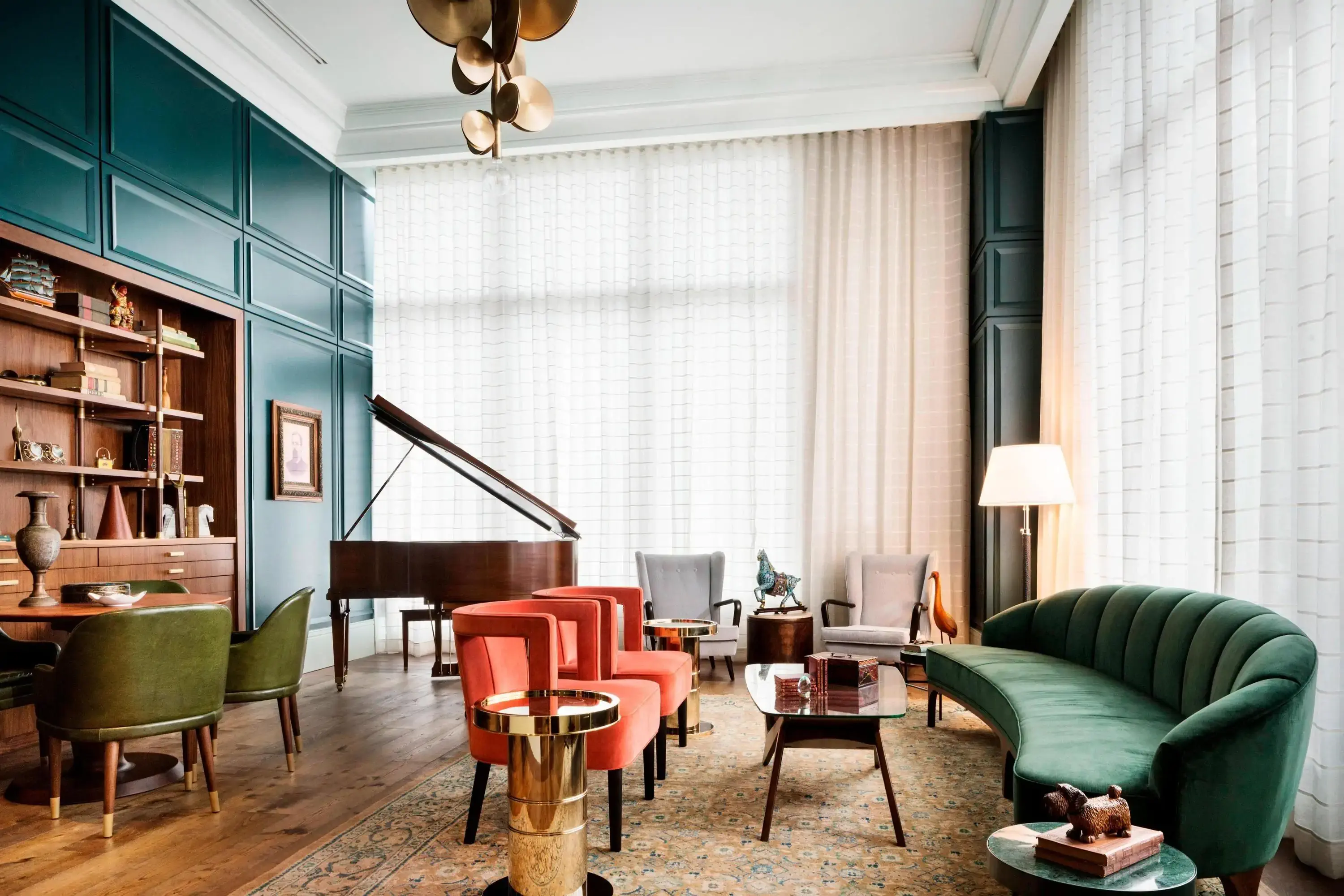 Interior view of eclectic hotel lobby with wood panelling, a grand piano and modern velvet seating