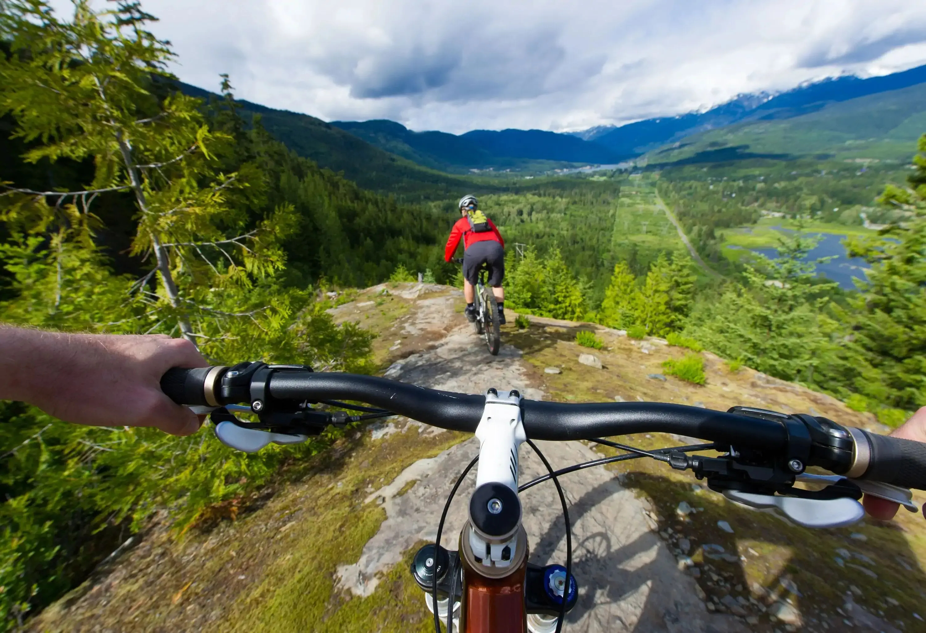 POV image of a mountain biker following another biker on a trail