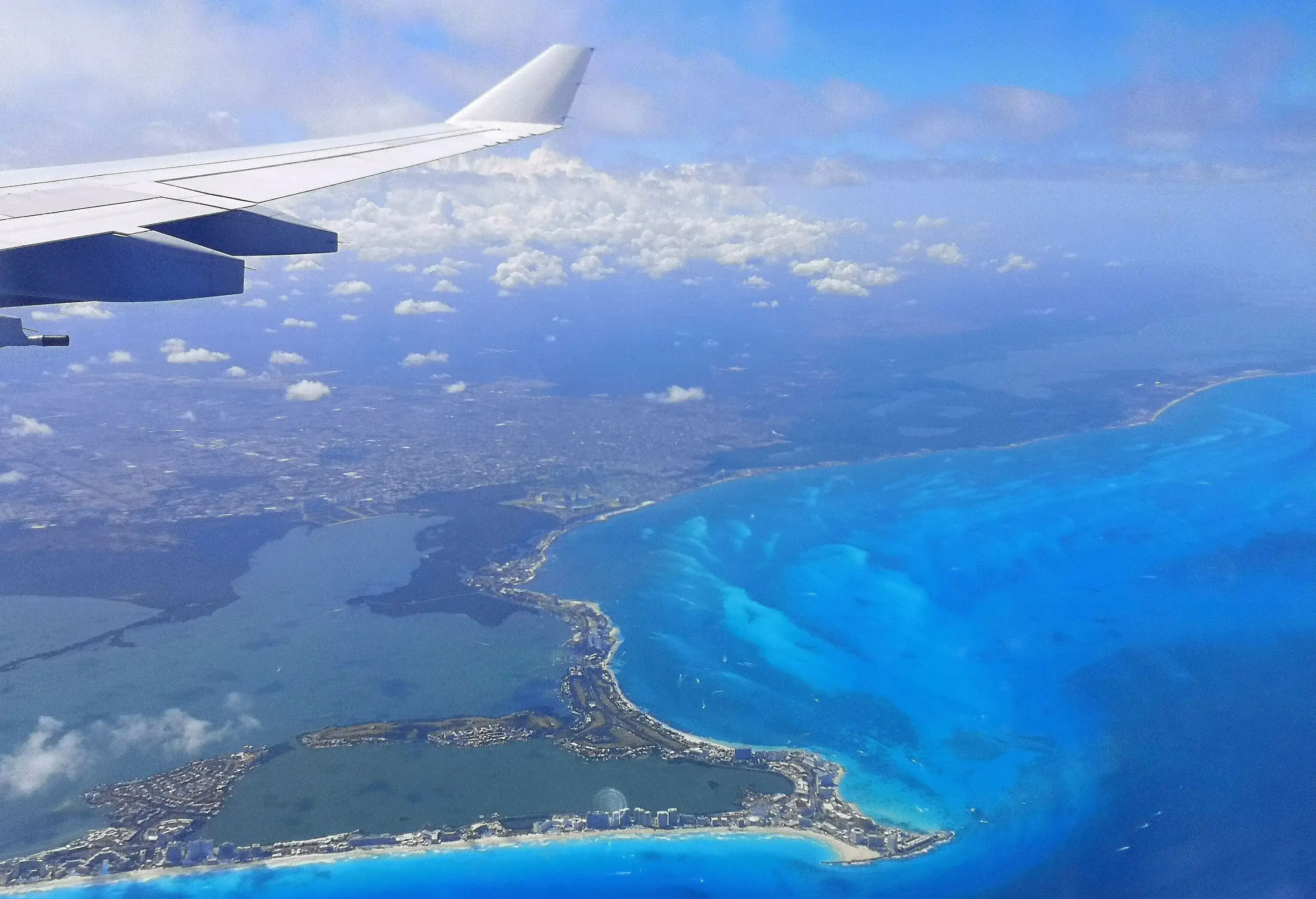Airplane wing with Mexican Cancun coast Carribean Sea