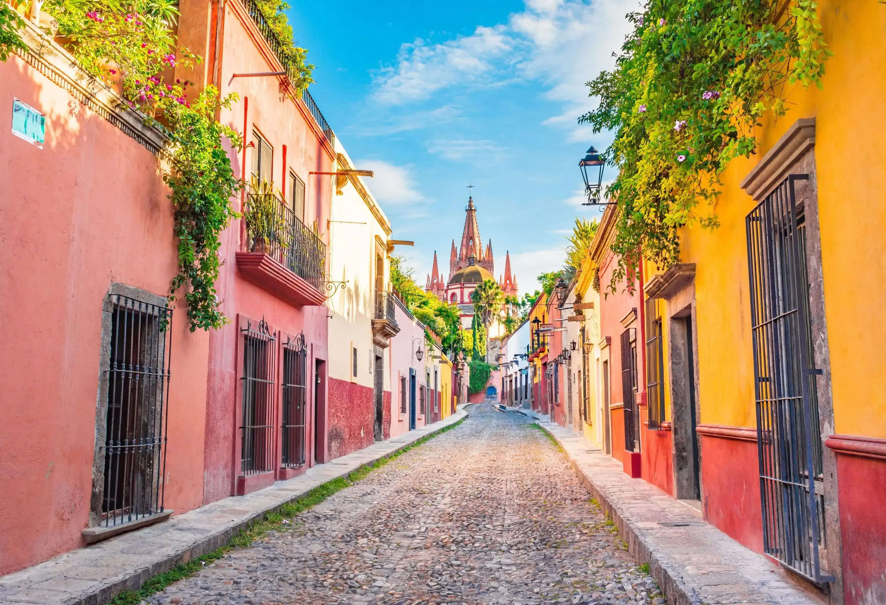 A stone-paved street bordered with multicoloured buildings.