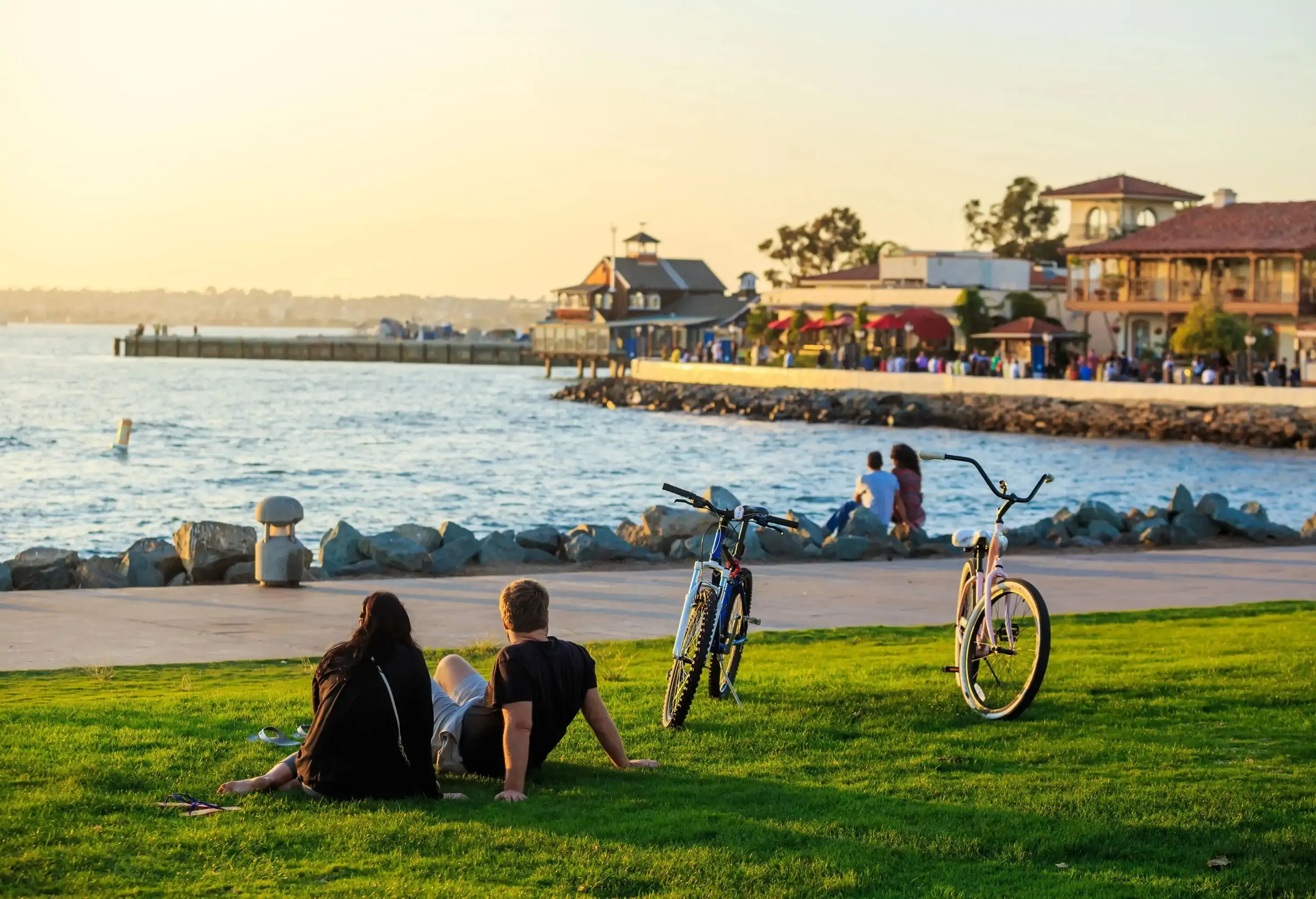 Couples sitting at sunset at San Diego Waterfront Public Park, Marina and the San Diego Skyline