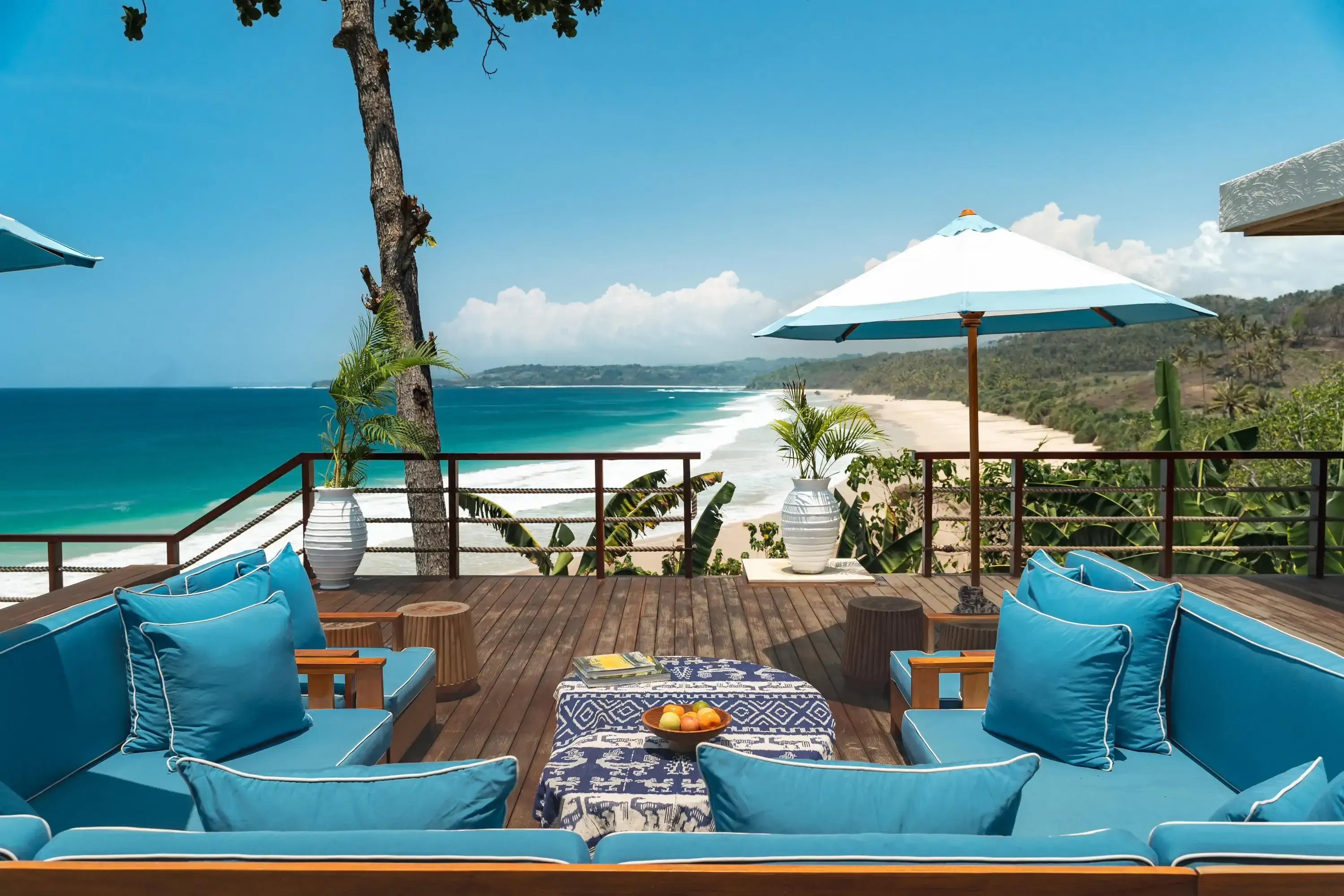 Luxury hotel terrace overlooking white sandy tropical beach