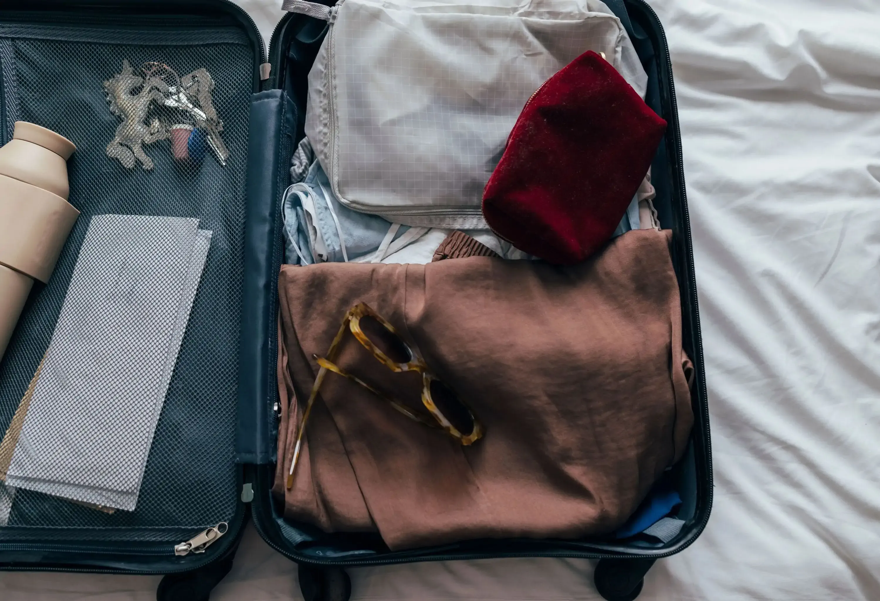 Carry-on luggage open on a bed and ready for packing