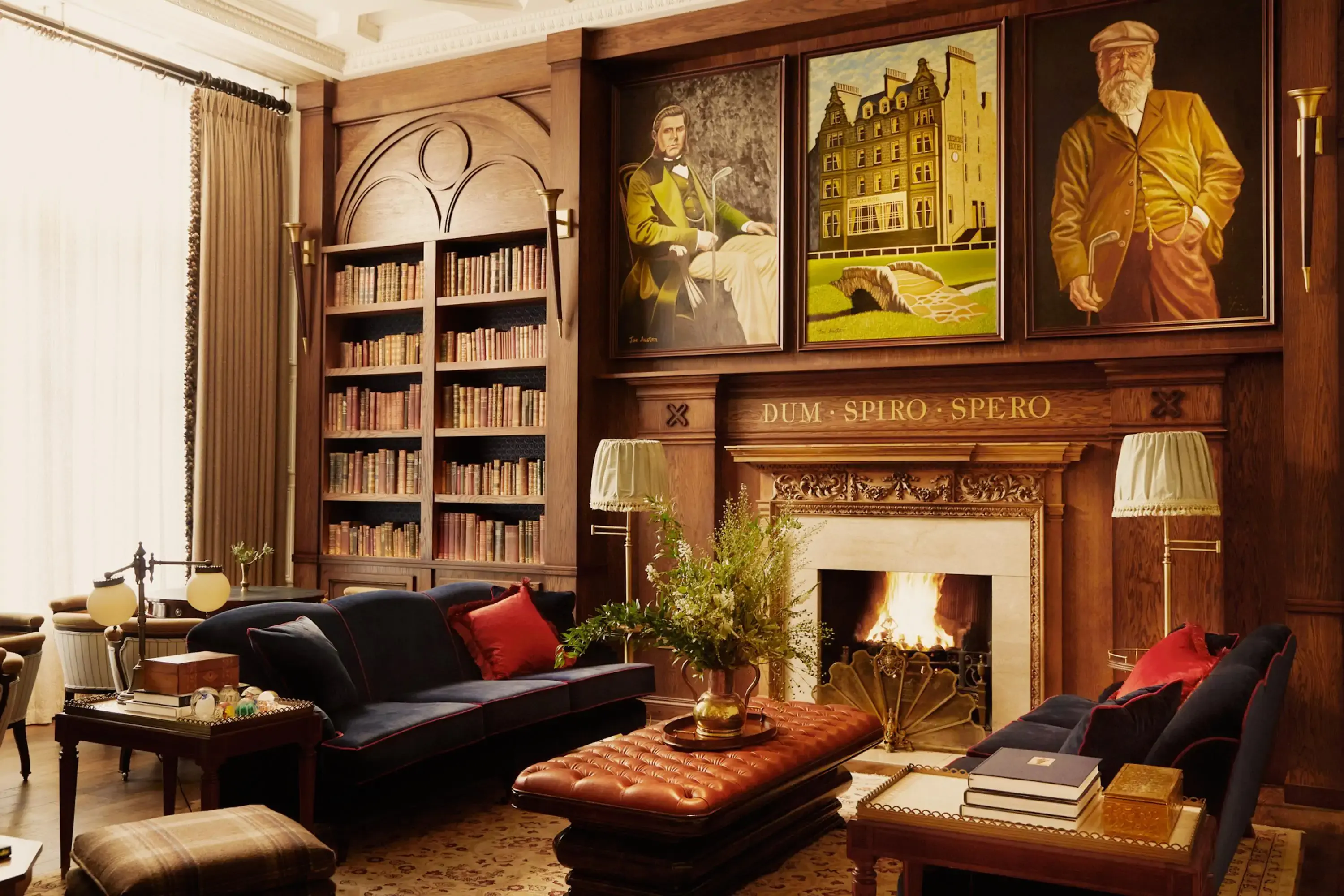 Traditional Scottish drawing room with fireplace, historial paintings and a library