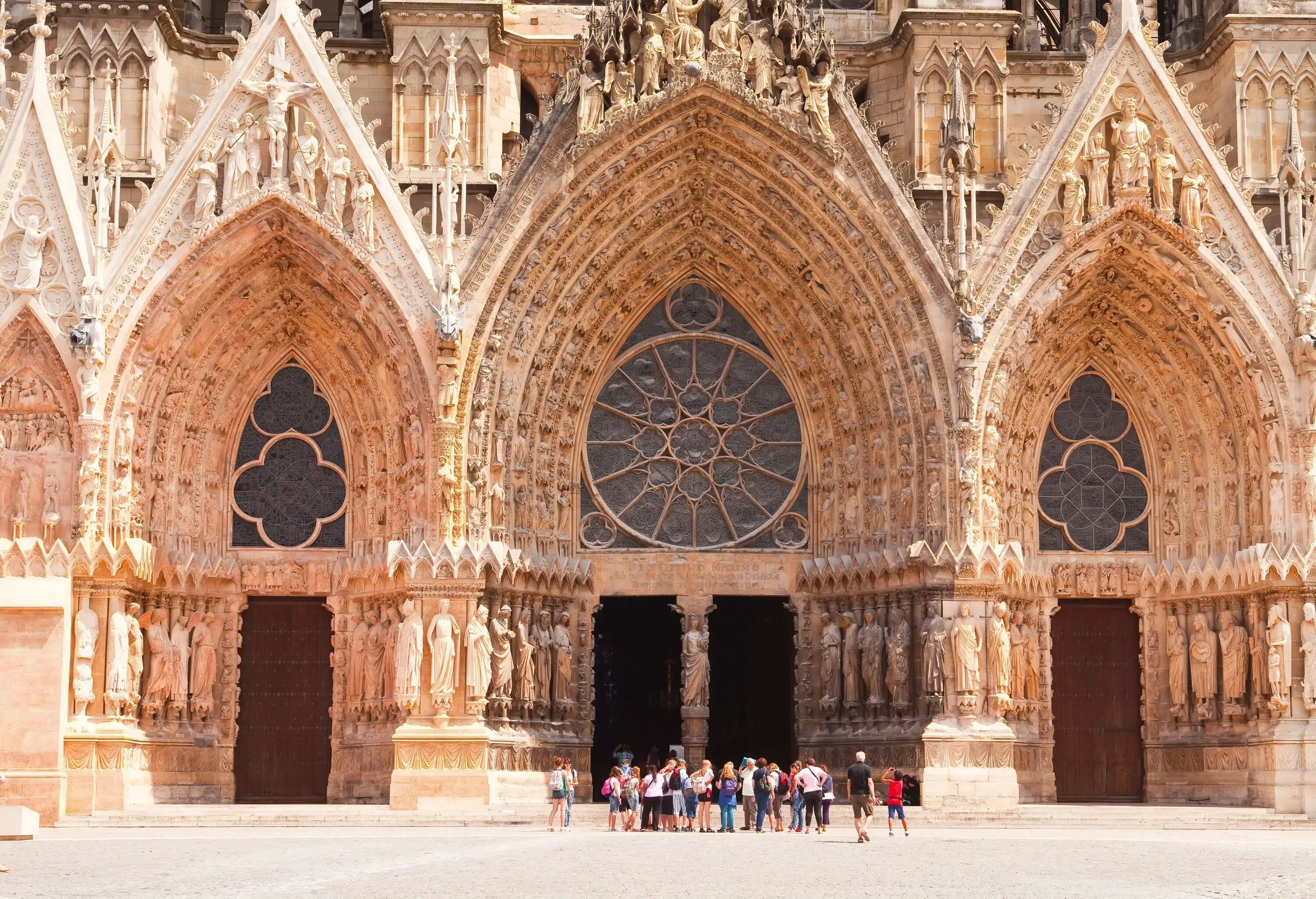 A unique church entrance doors into the nave with a large rose window and many sculptures on the walls.