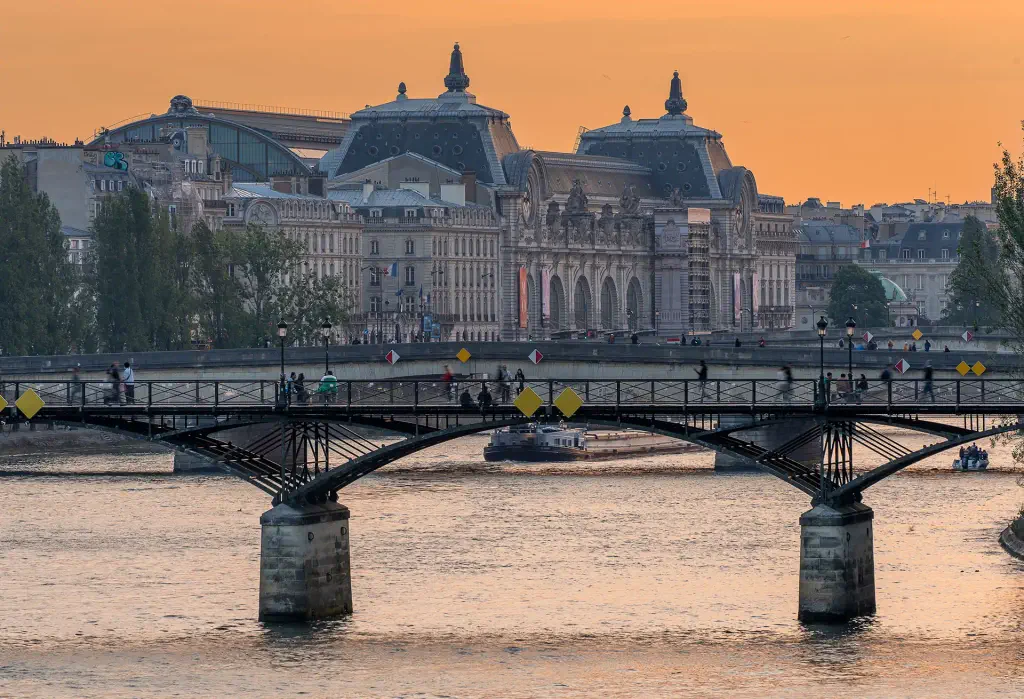 Bridge over Seine at sunset with Musée d'Orsay in the background, Paris.