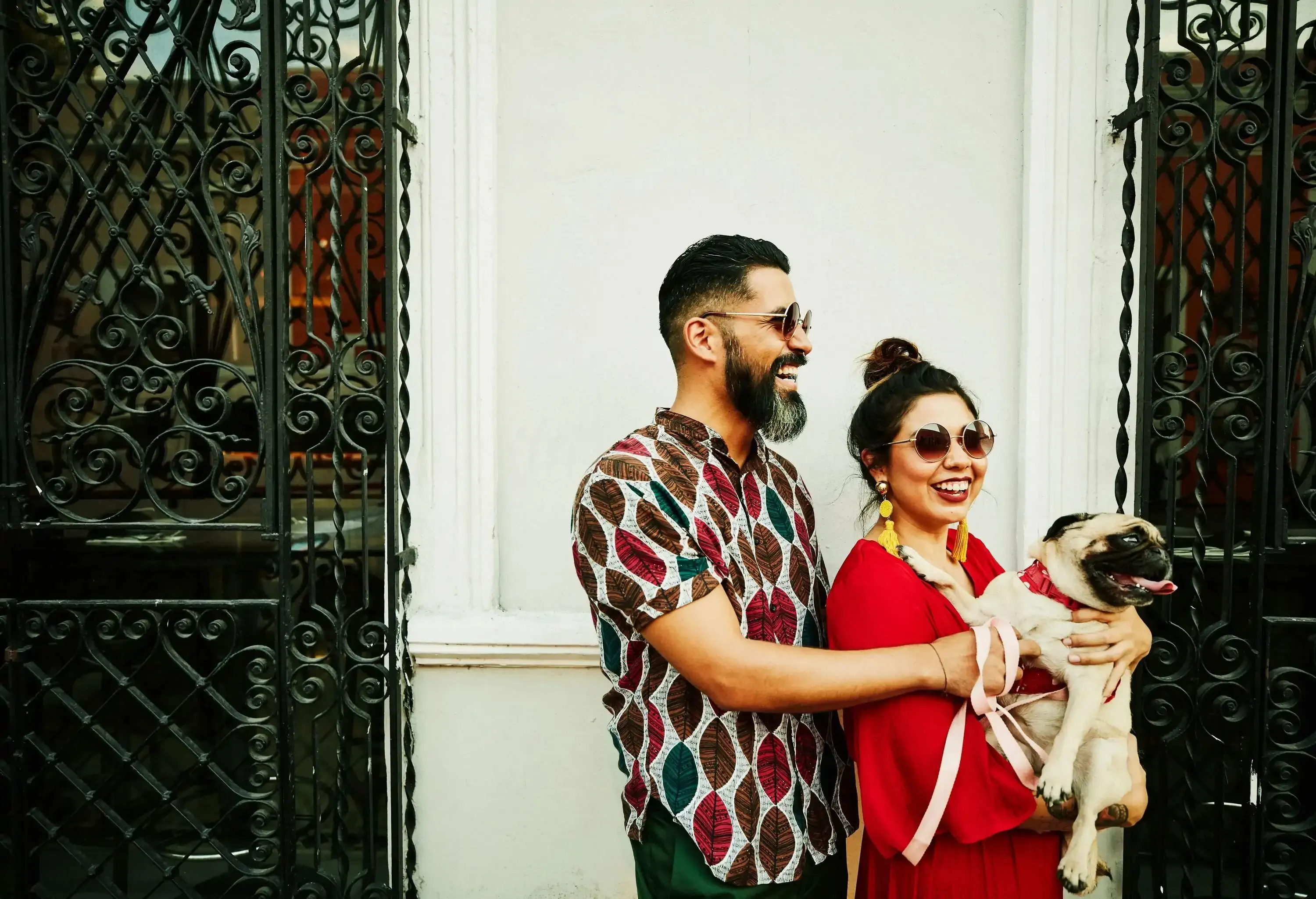 A smiling happy couple with the female holding her dog.
