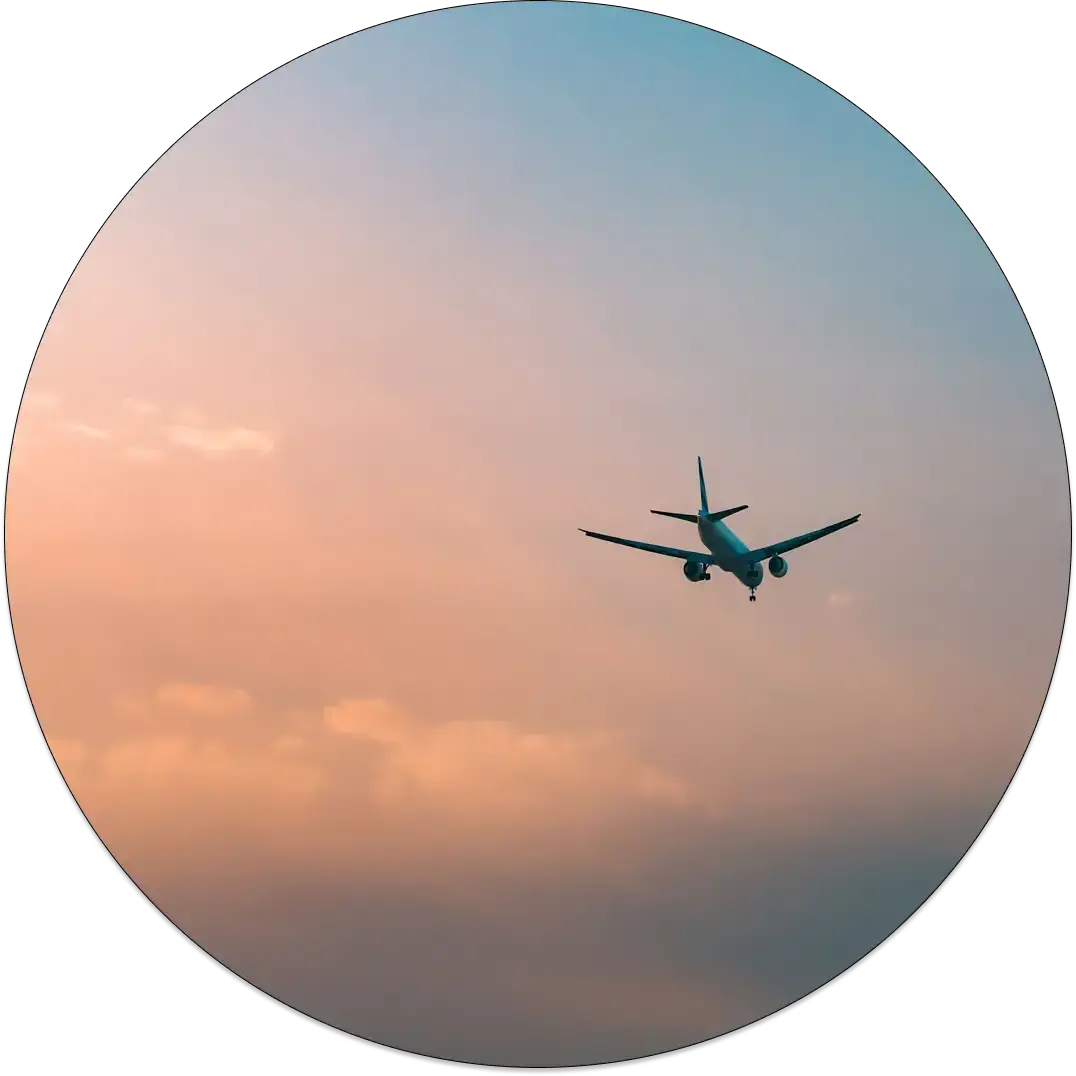 An airplane flying through a sky with red and blue hues.