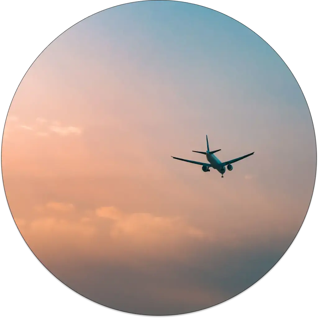 An airplane flying high with sun setting down