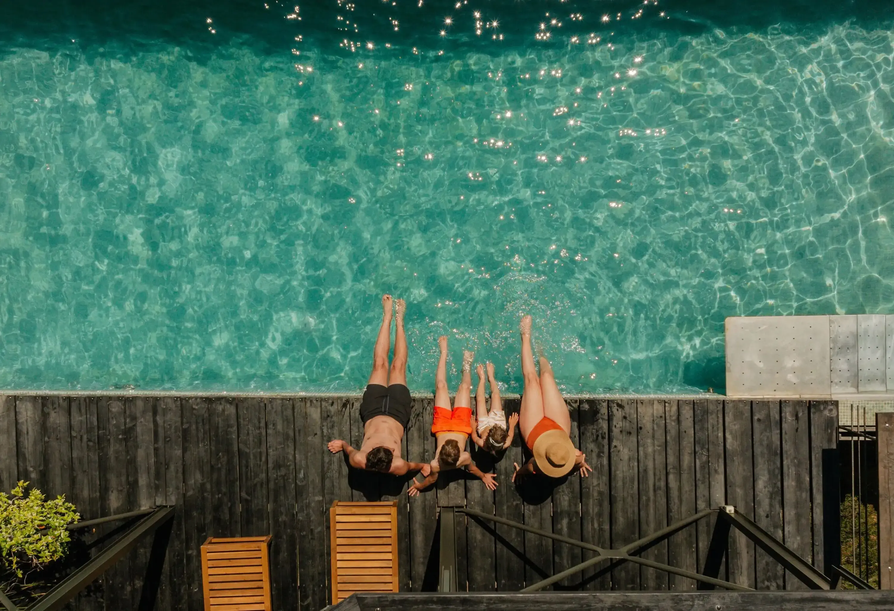 Photo of a young family with two children, relaxing by the pool in a vacation rental villa