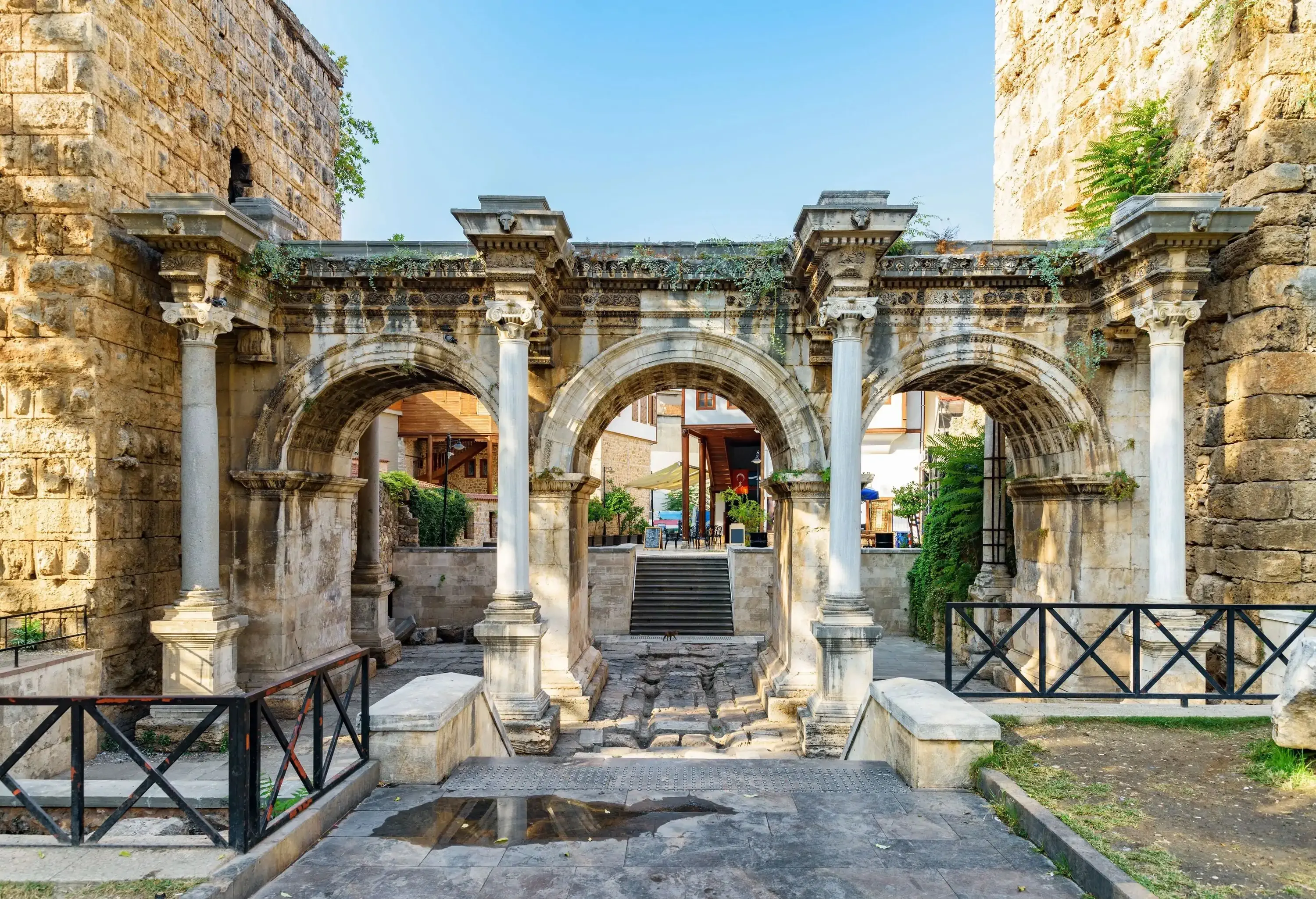 A city gate with three arches and columns leading to the city centre.