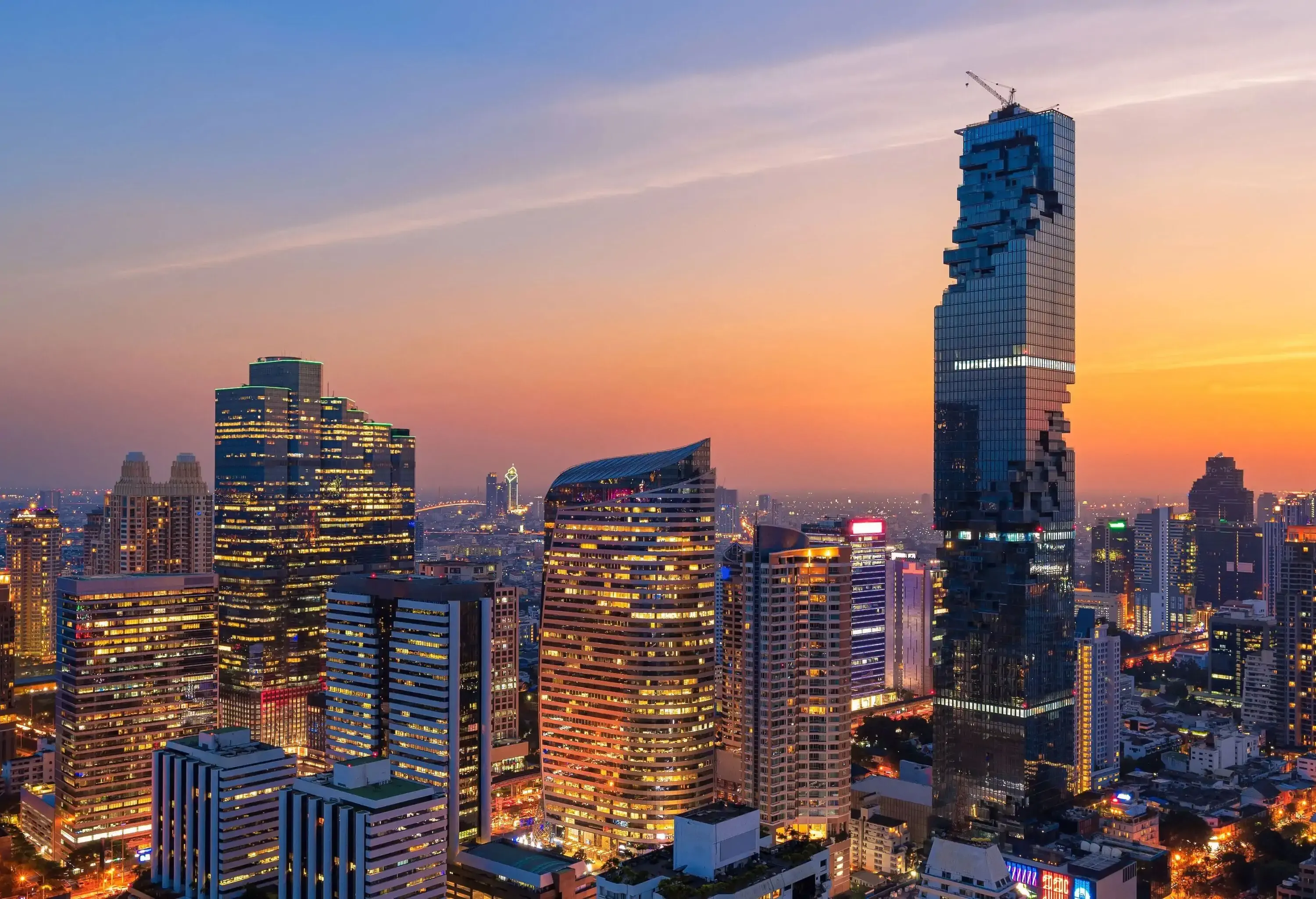 A metropolitan skyline adorned by modern skyscrapers under a sunset sky.