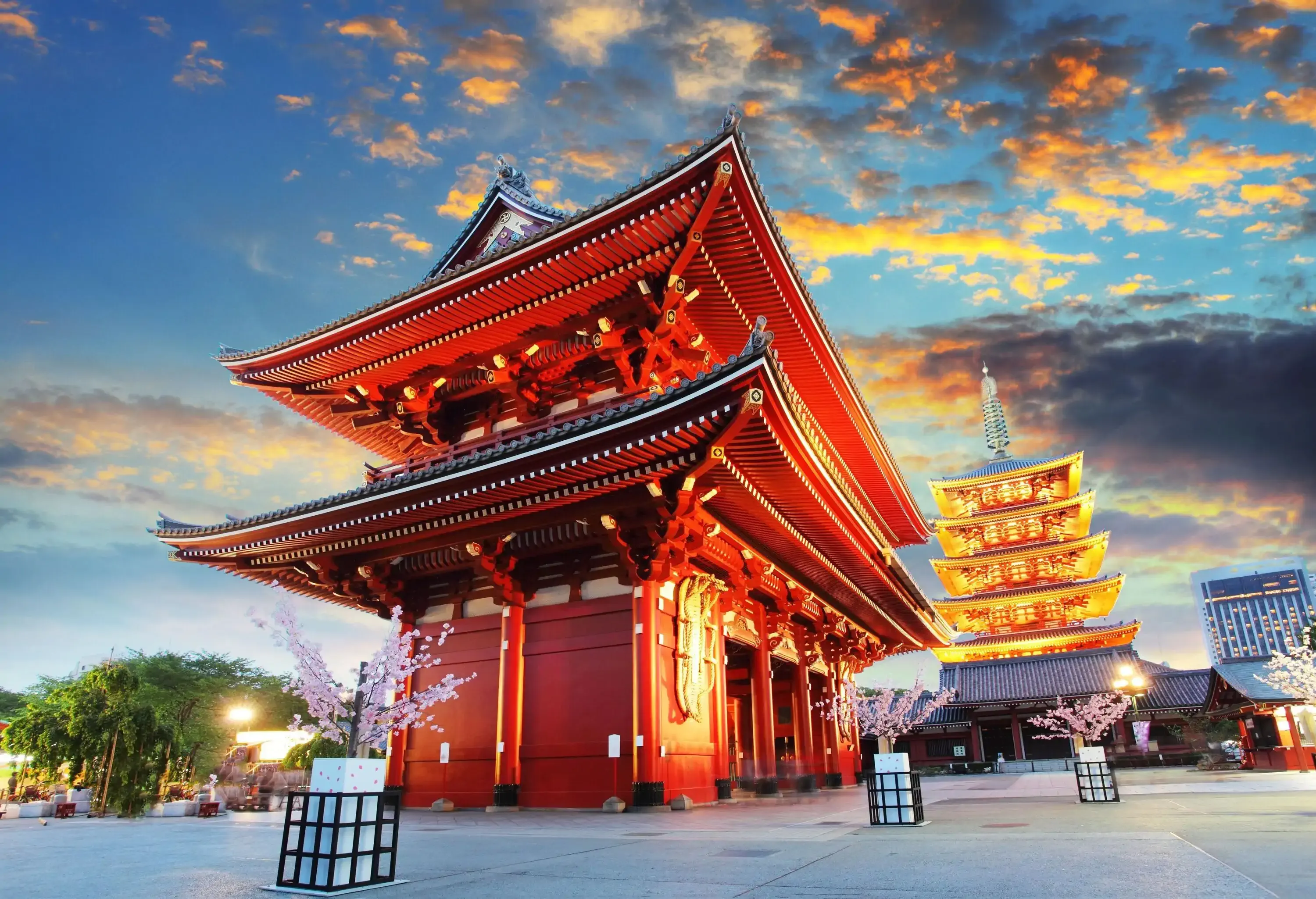 The revered Sensō-ji temple takes centre stage in the foreground with its magnificent presence, while a brilliantly illuminated pagoda stands tall in the background.