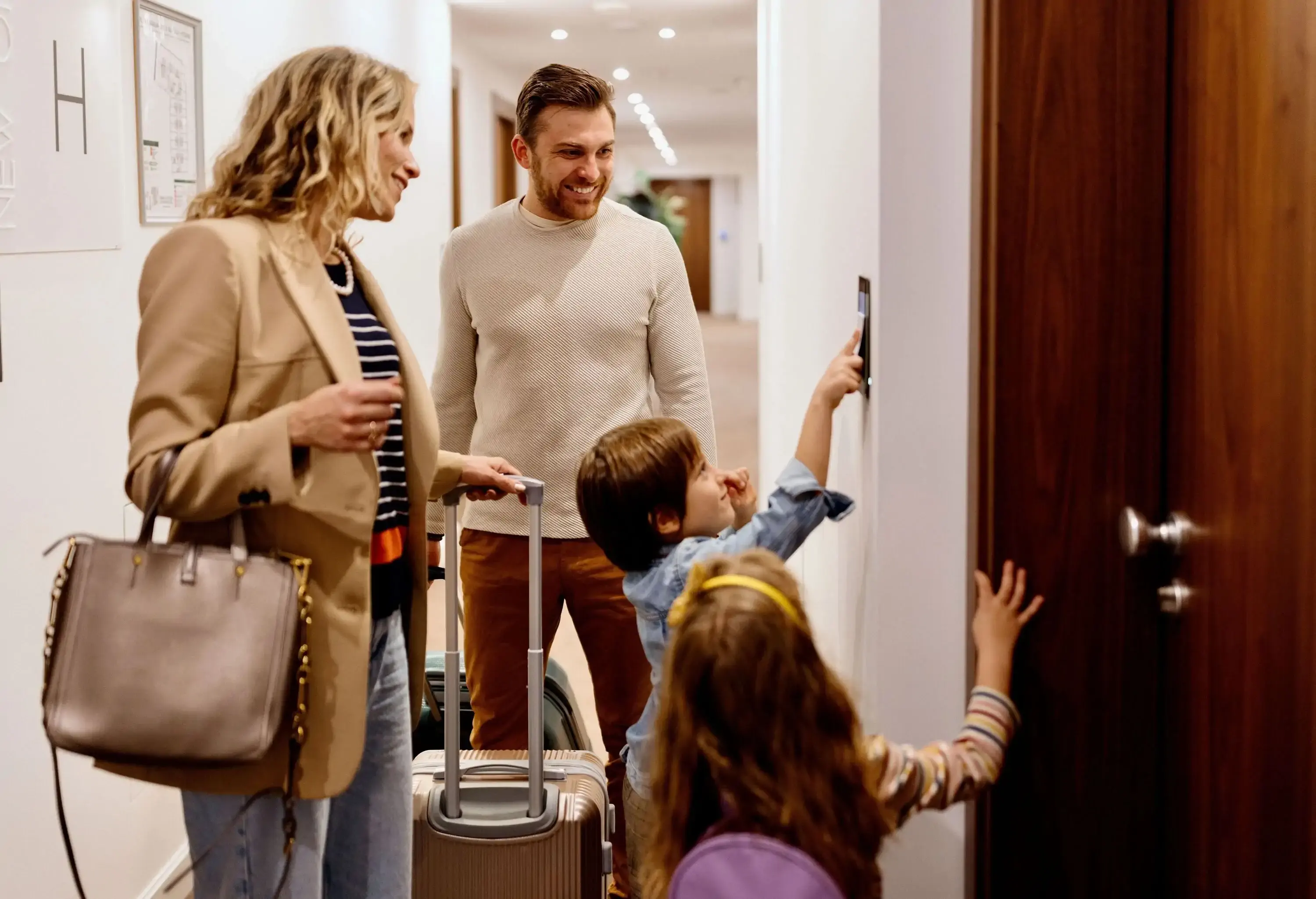 Family searching for the room in a luxury hotel. Family pulling luggage to the hotel room