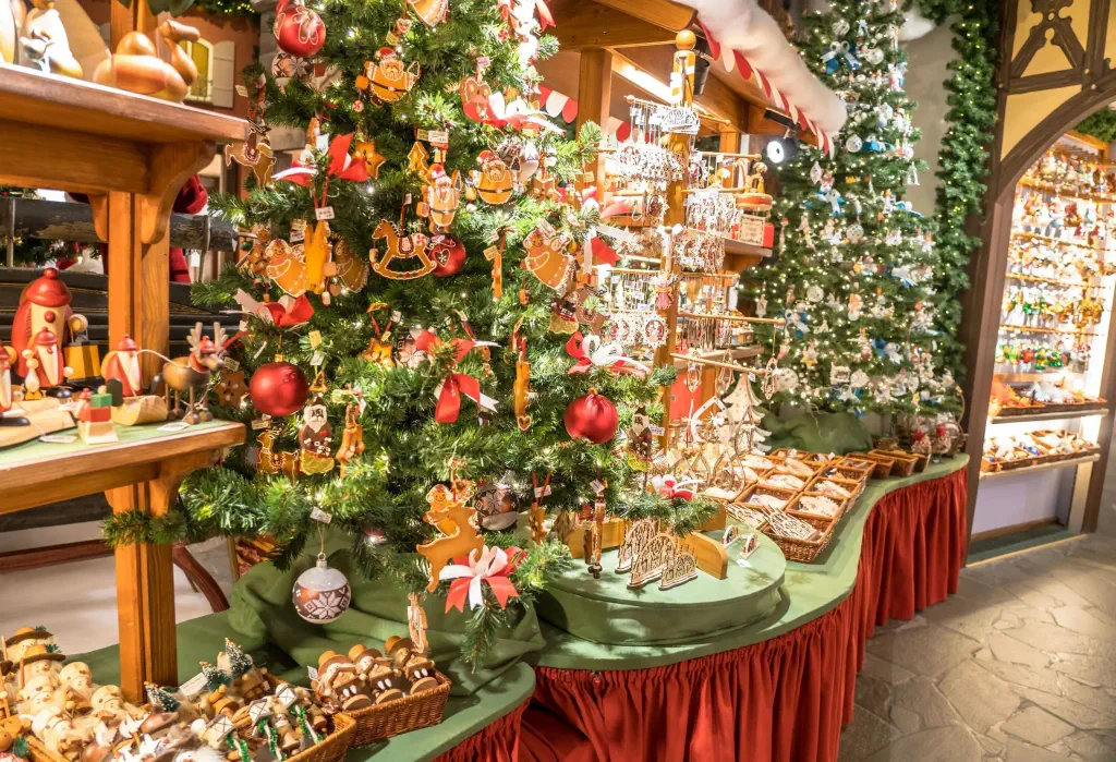 An array of Christmas ornaments in wooden baskets and decorated Christmas trees in a store.
