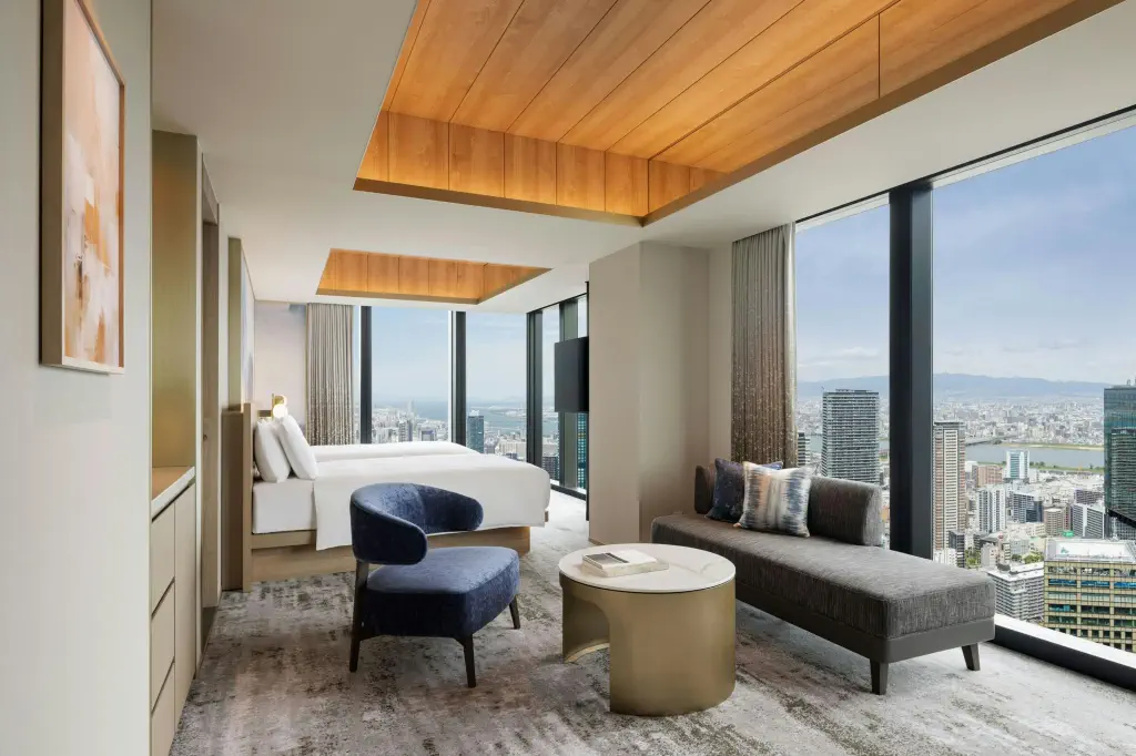 A luxury contemporary hotel room in high rise building with windows overlooking city