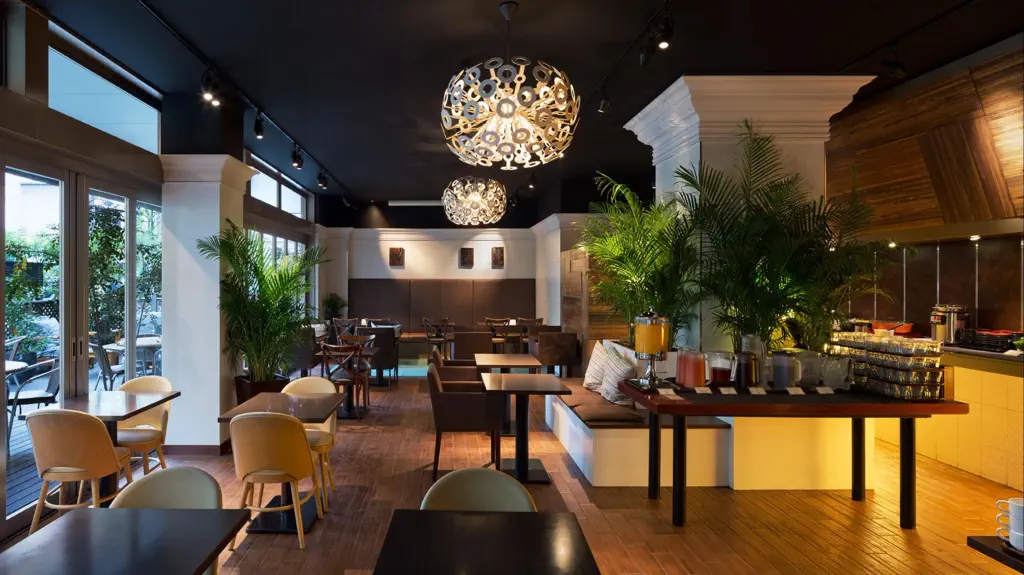 Breakfast room of a hotel with buffet, plants and contemporary crystal chandeliers