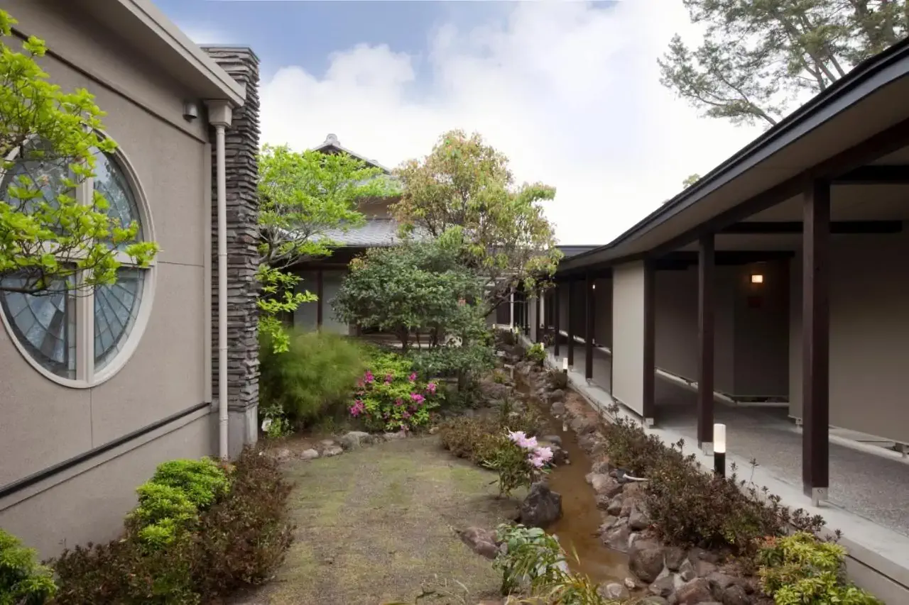 A Japanese garden with an adjacent hotel building