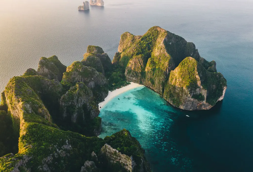 A stunning cove beach with clear turquoise water encompassed by limestone karsts.