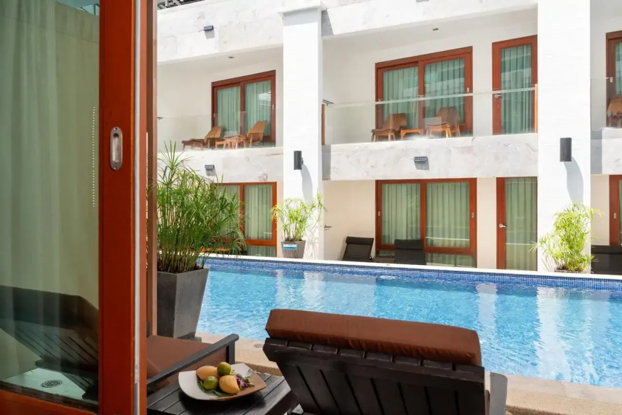 View of a terrace with pool from the window of a poolside hotel room