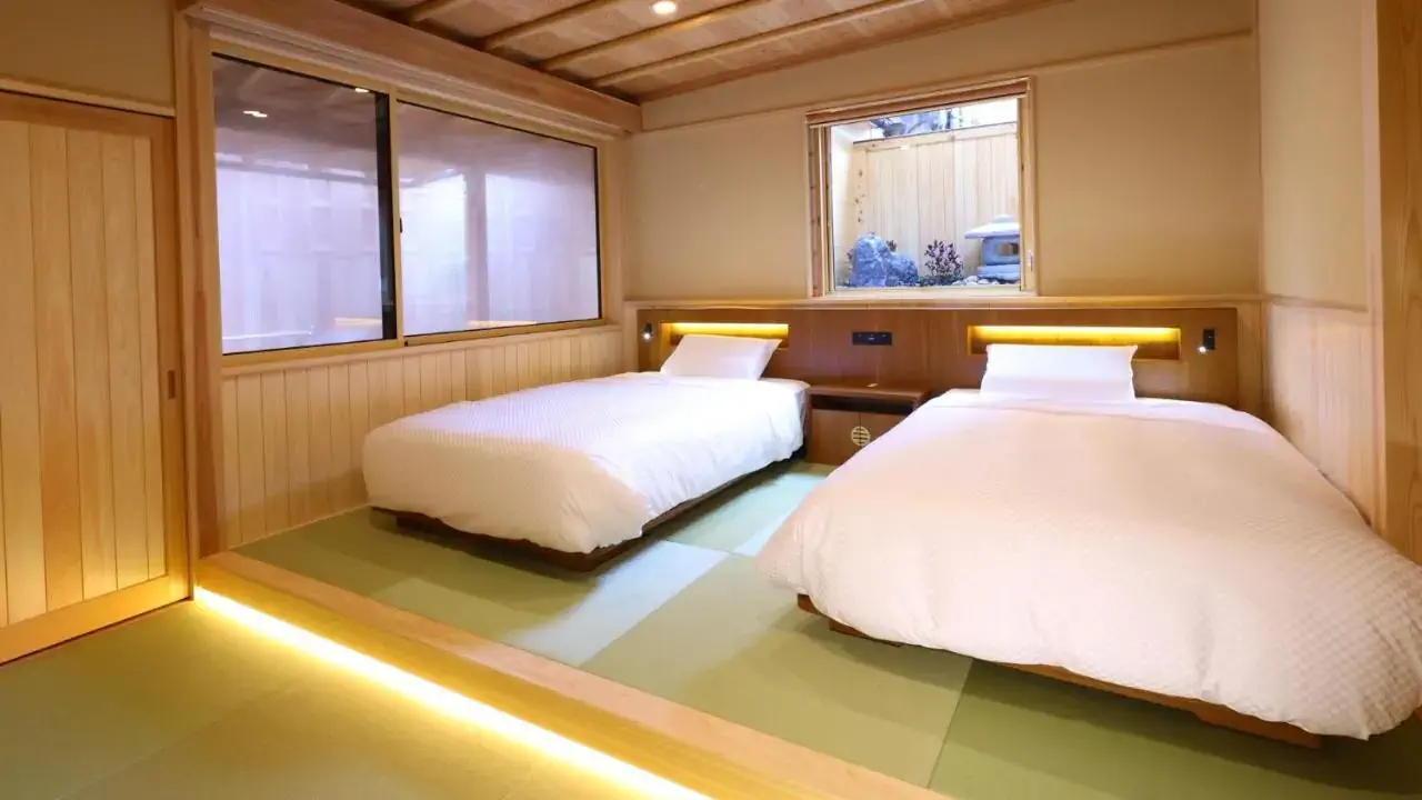 A Japanese bedroom with two beds over a wooden platform