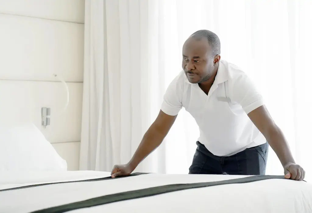 African housekeeper making bed