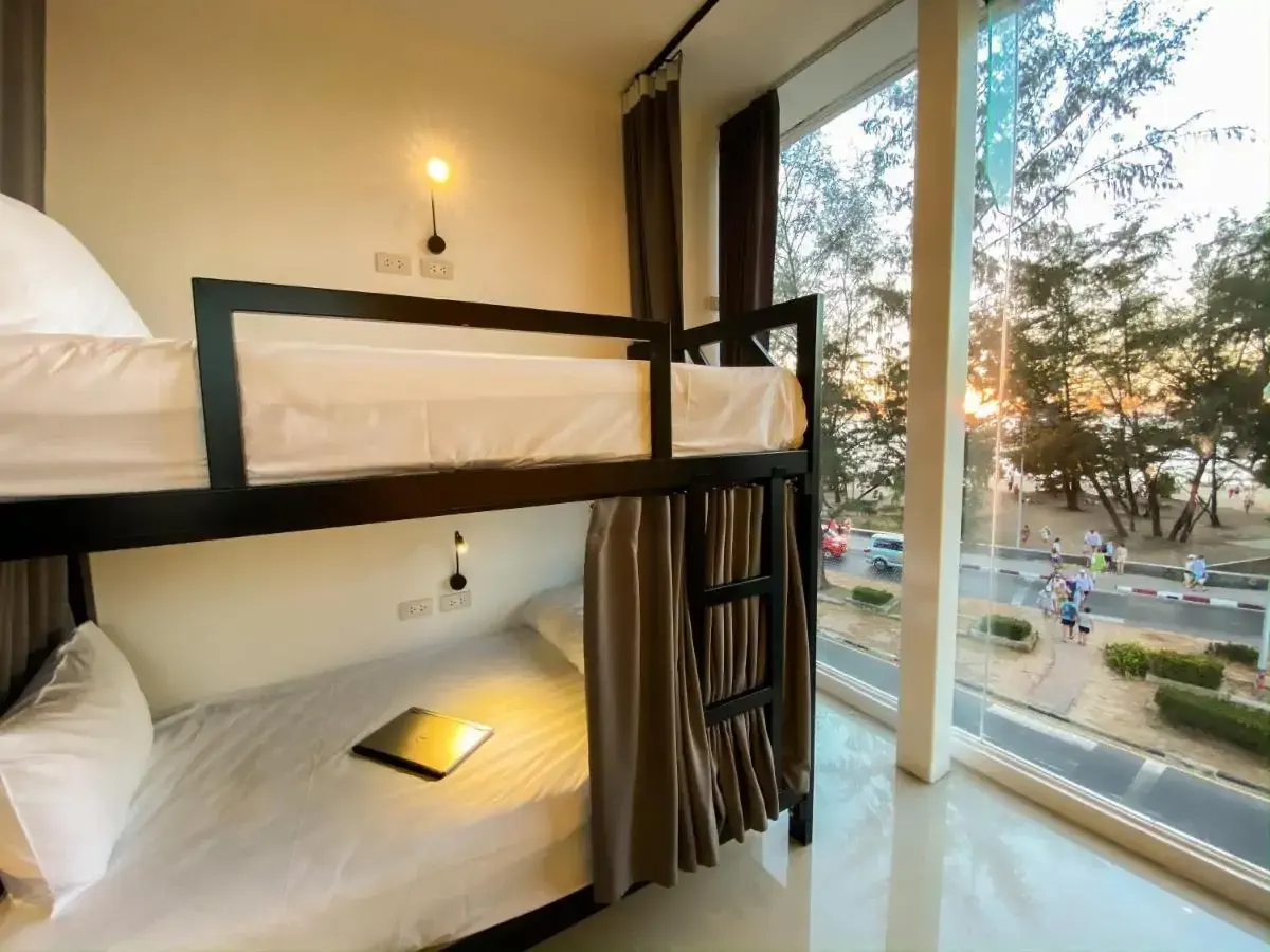 A modern bunk bed of a hostel by a window. overlooking the street