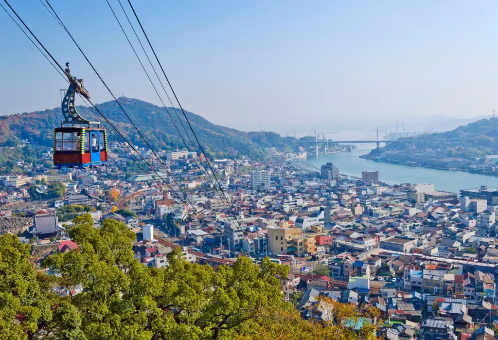 A cable car gliding above a populous city.