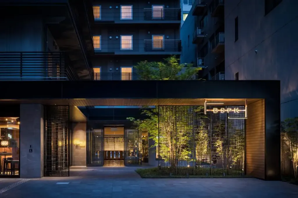 Exterior of contemporary urban hotel at night with illuminated plants