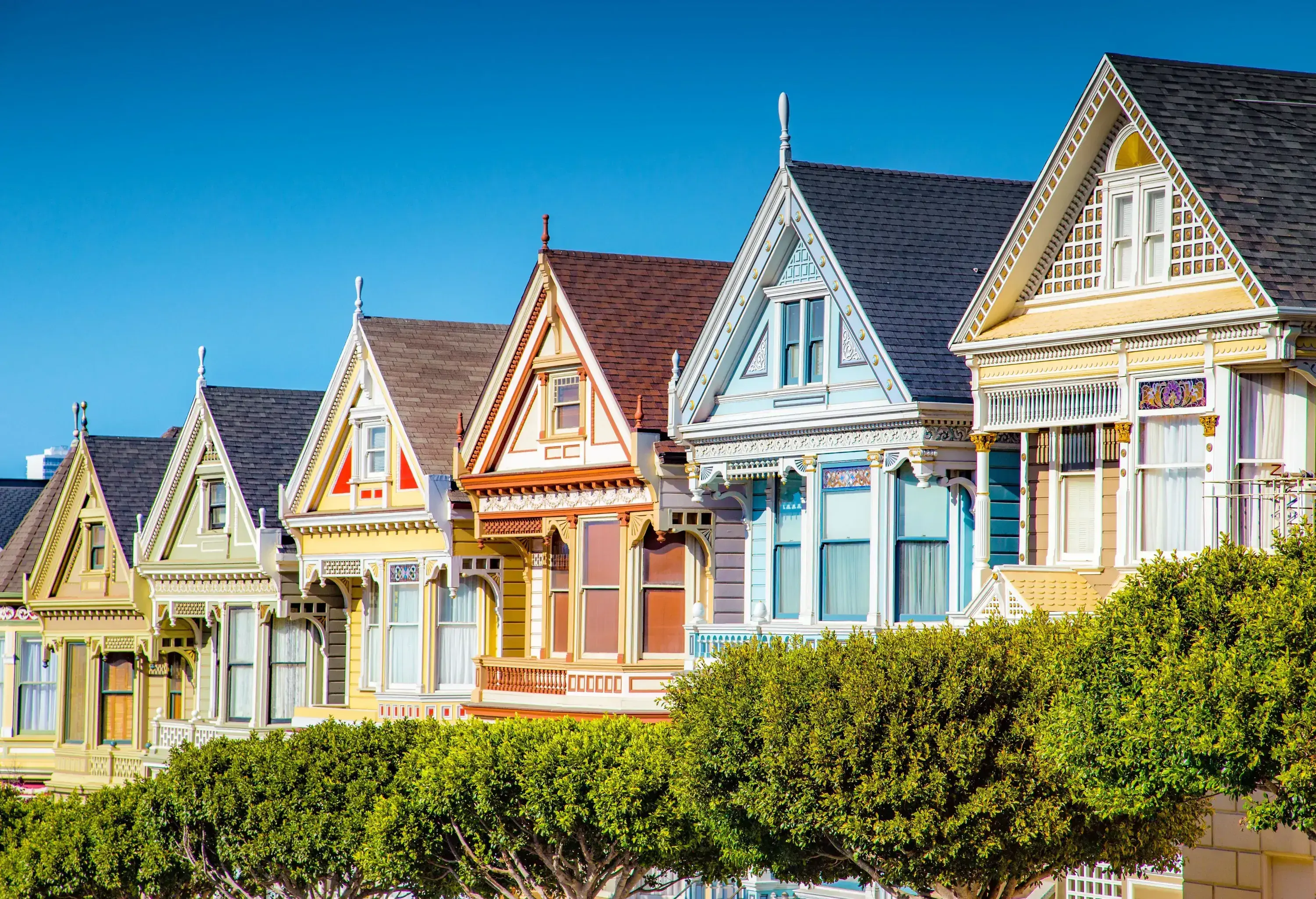 Victorian-style rowhouses with gable roofs and brightly coloured façades.
