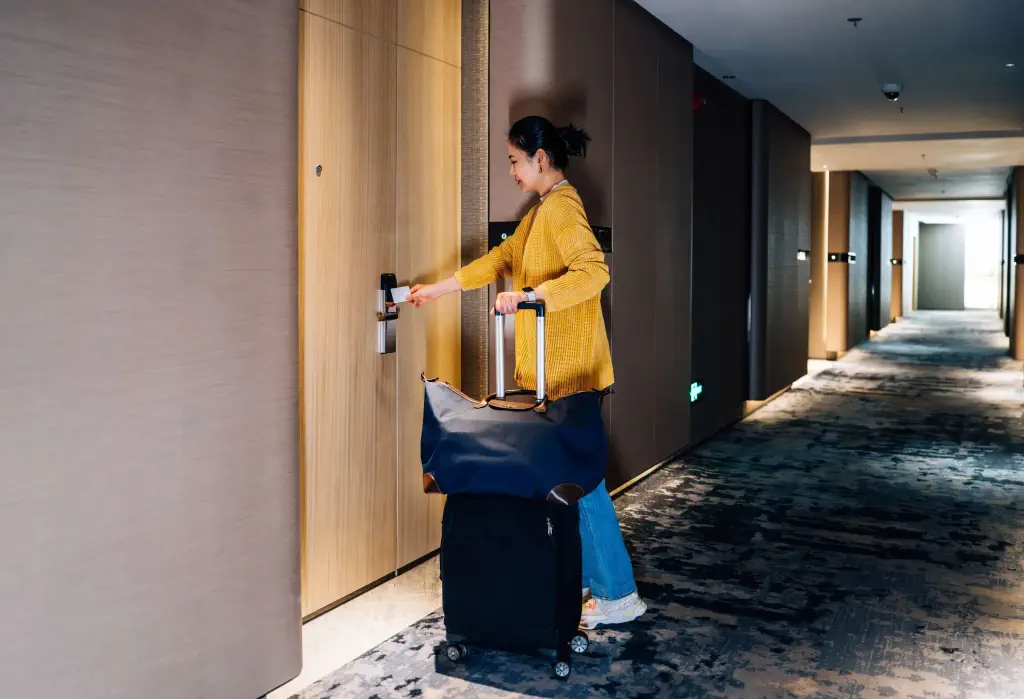 Asian businesswoman opening her hotel room door with a keycard after checking.