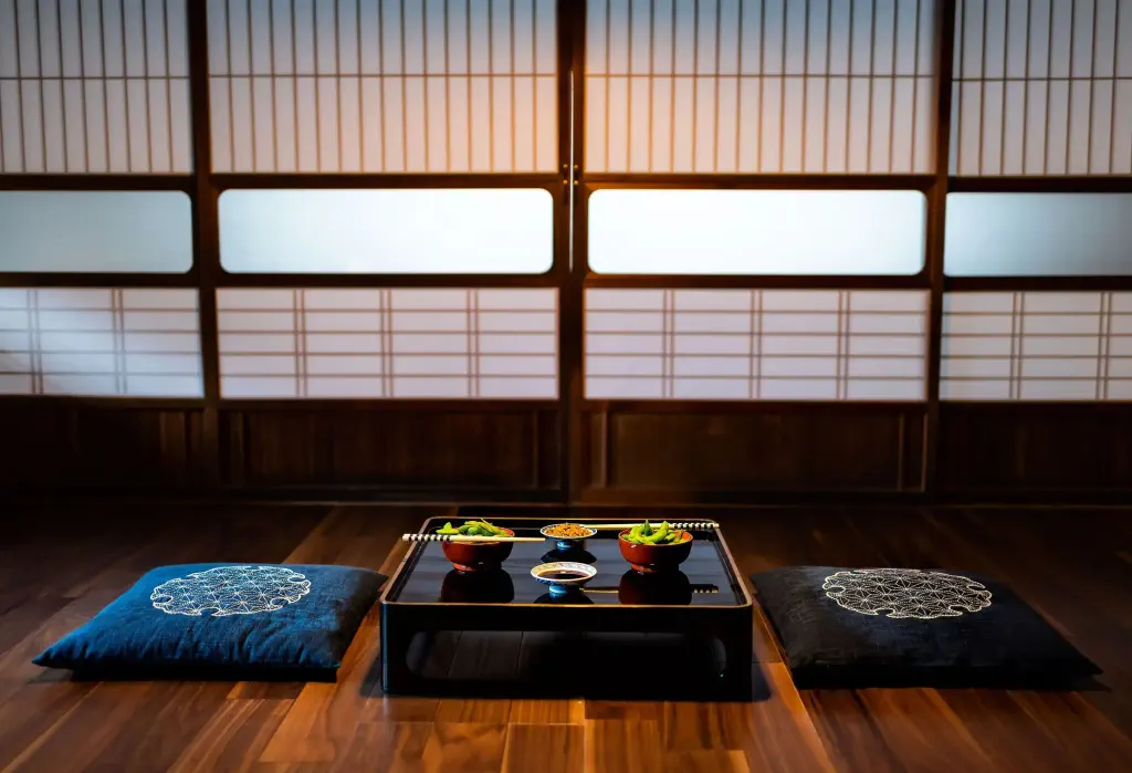 Two meal bowls served on a black low lacquered table with cushions on the wooden floor.