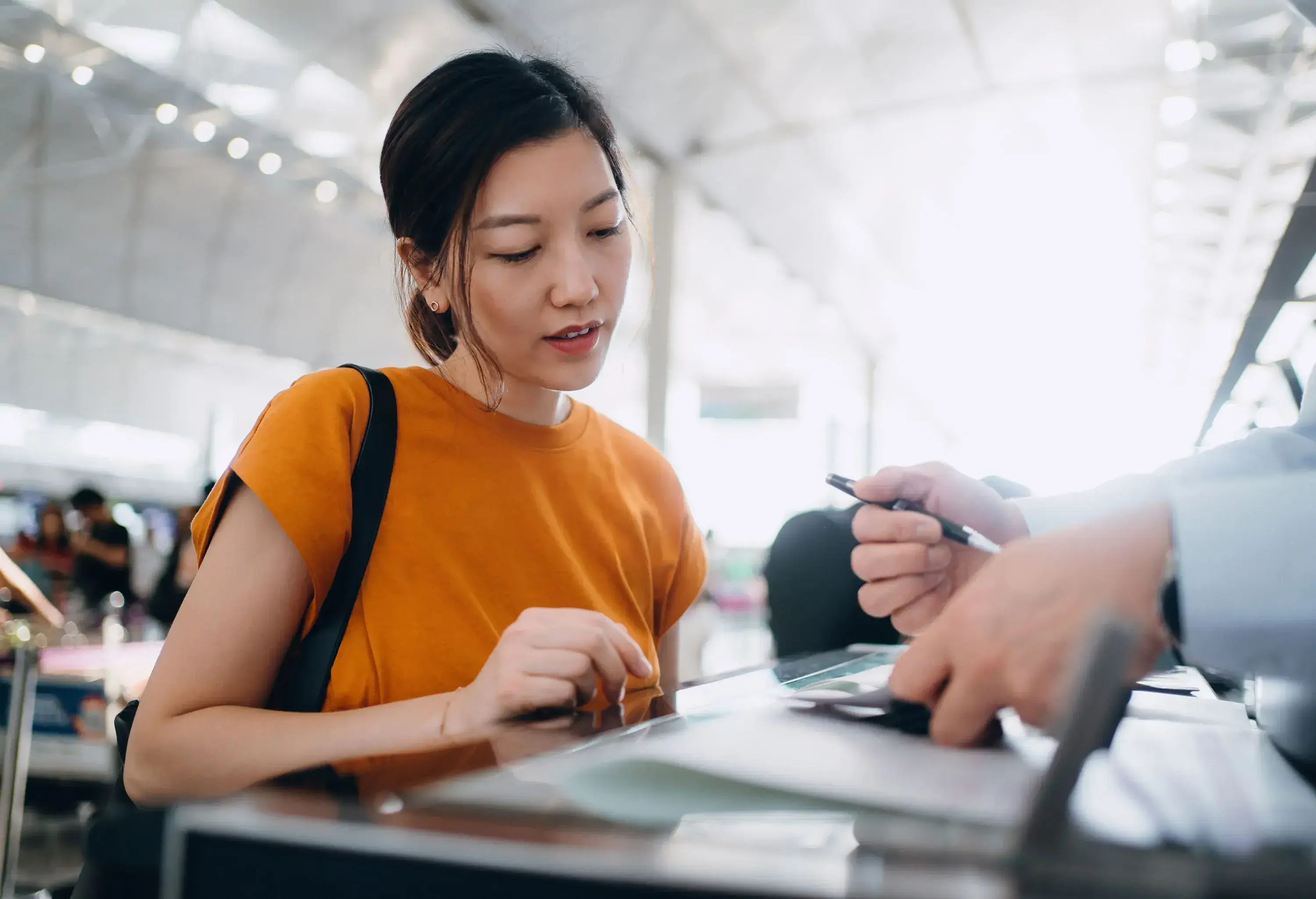 Young Asian woman travelling by airplane and doing check-in at airline check-in counter at airport terminal. Business travel. Travel and vacation concept