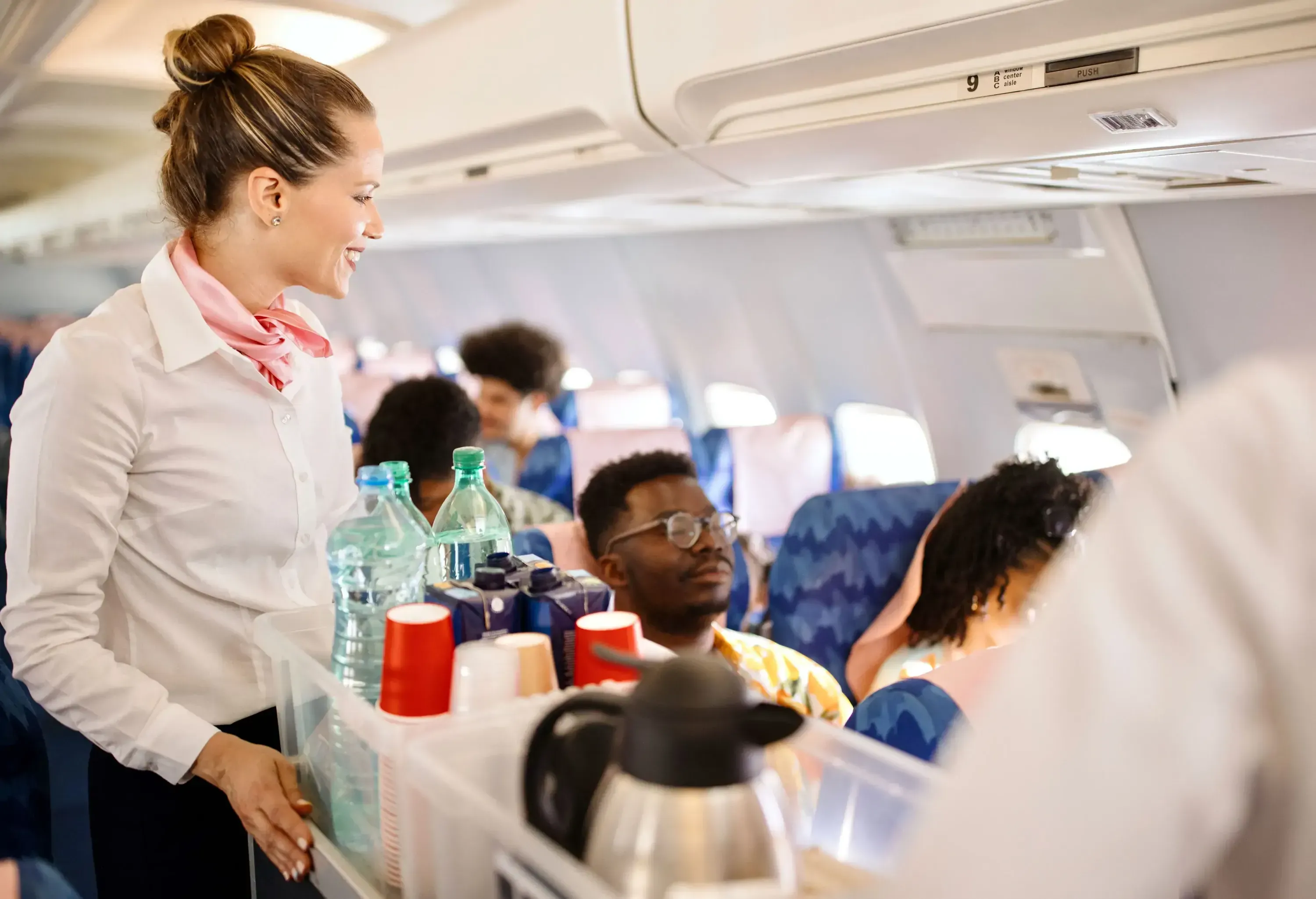 Cabin crew pushing service cart and serve to customer on the airplane during flight