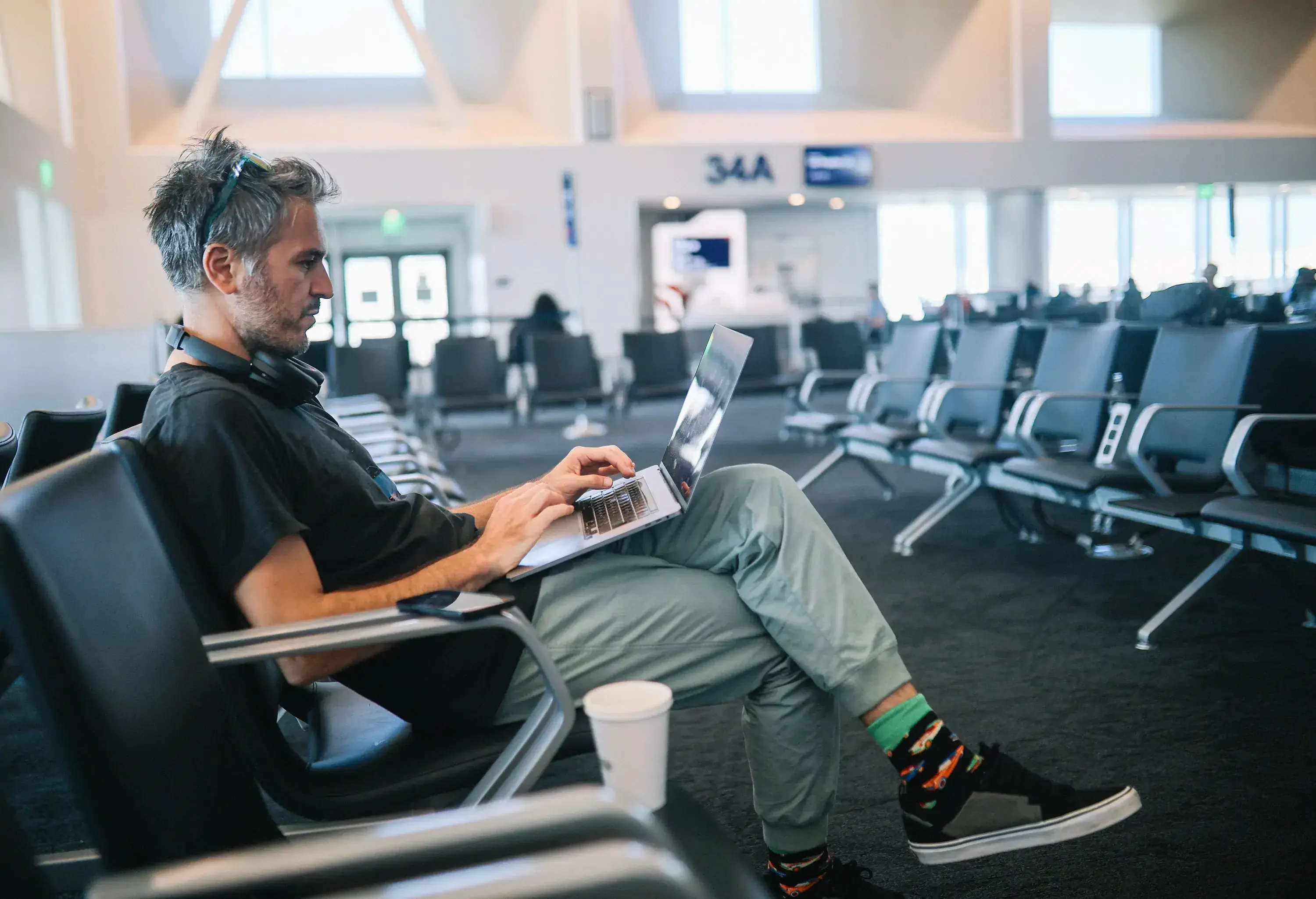 Man working on the laptop while waiting for the flight at the Los Angeles airport gate.