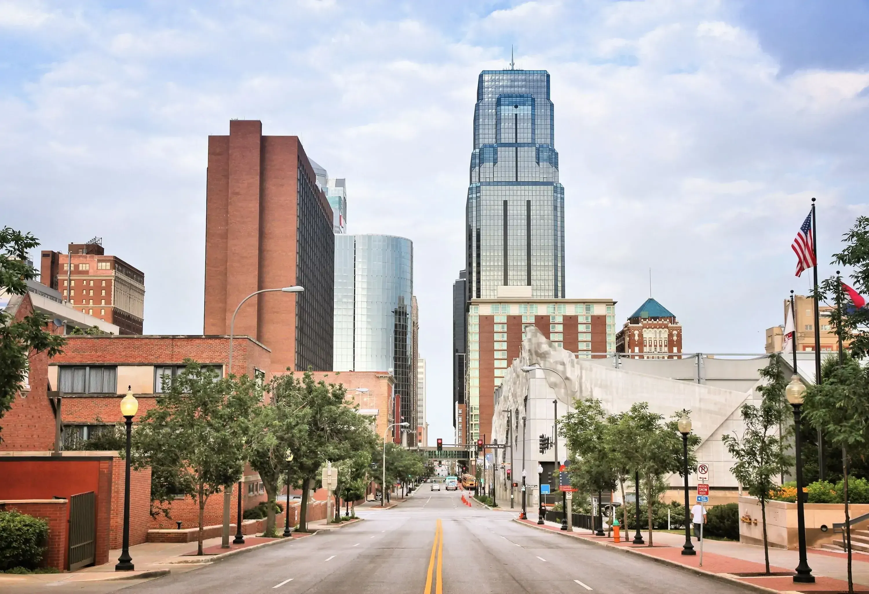 A long street runs in the middle of the imposing tall buildings.