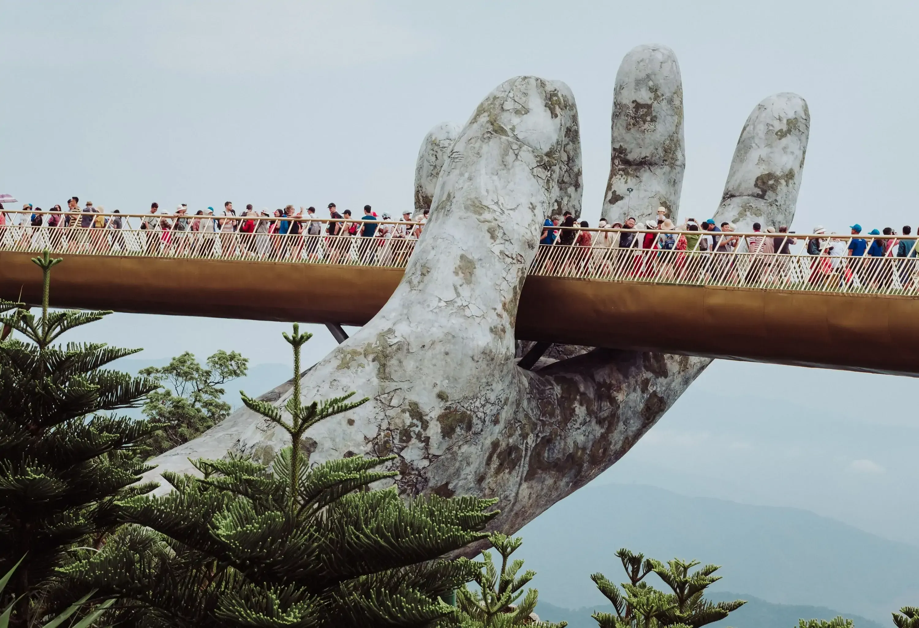 Ba Na Hills offers the surreal sight of a crowd of people leisurely walking on a bridge that appears to be held up by a massive stone hand.