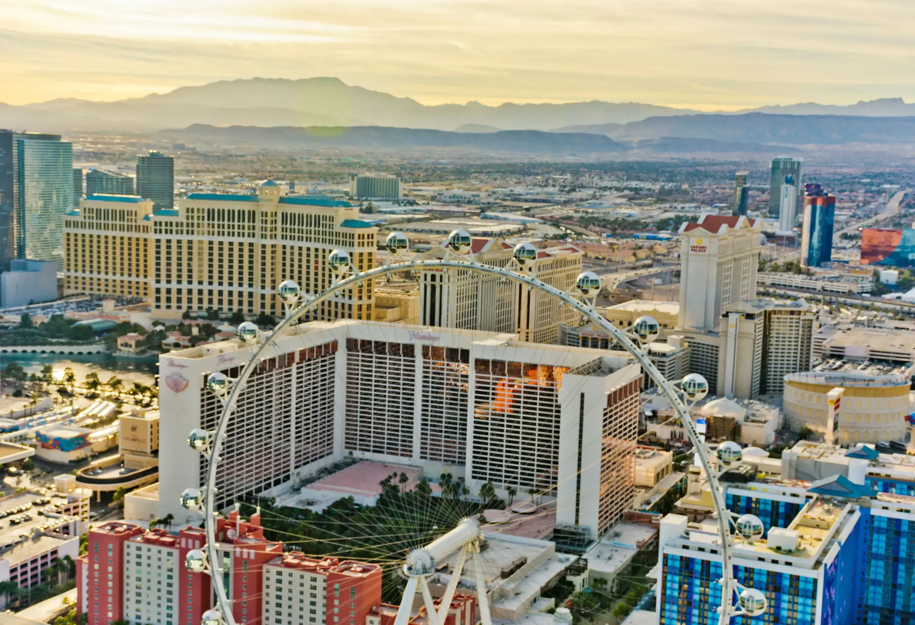 A big Ferris wheel, massive hotel buildings ,and entertainment centres making up a cityscape.