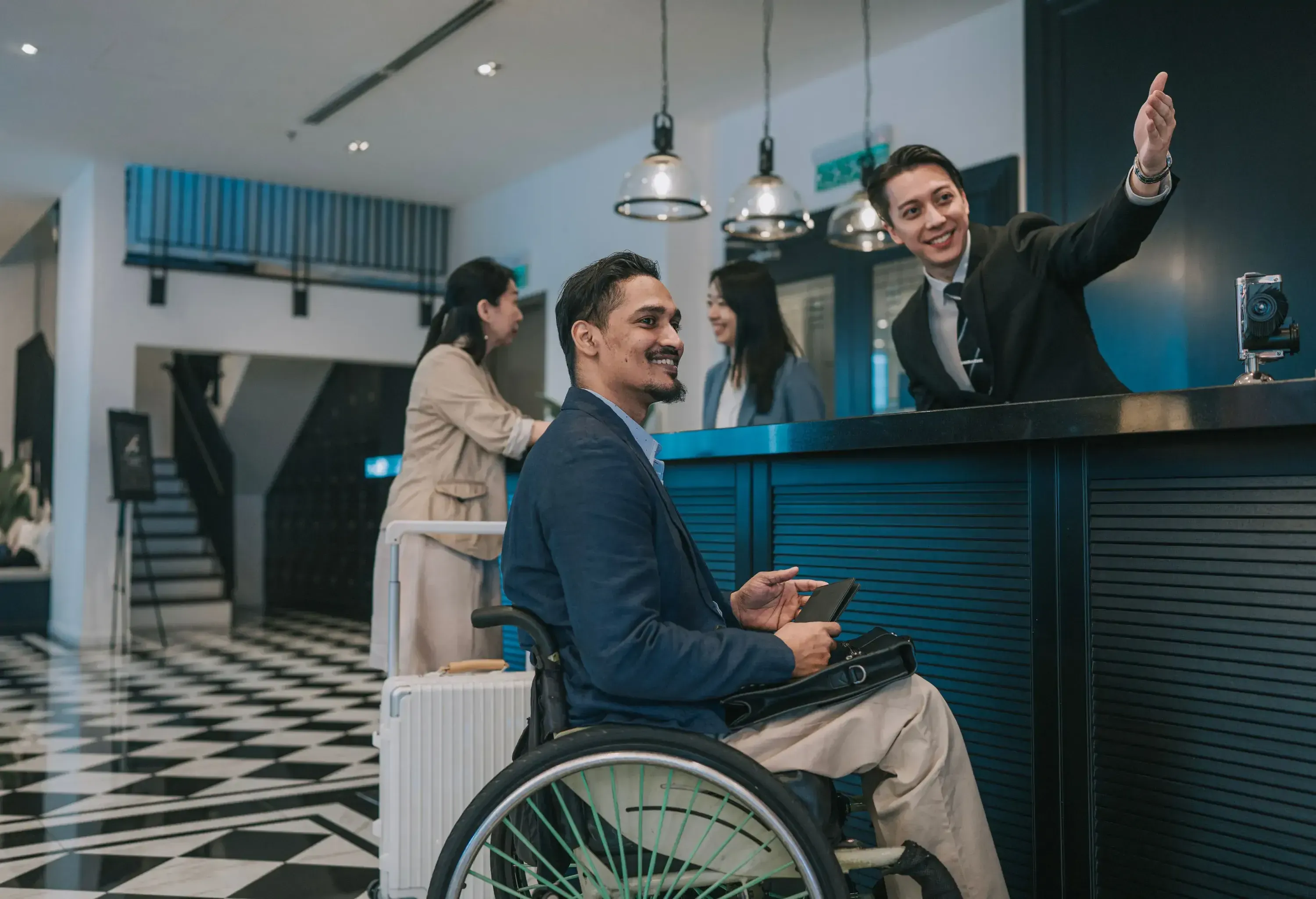 Asian Receptionist at airport lounge / hotel lobby checks in travelling business executives