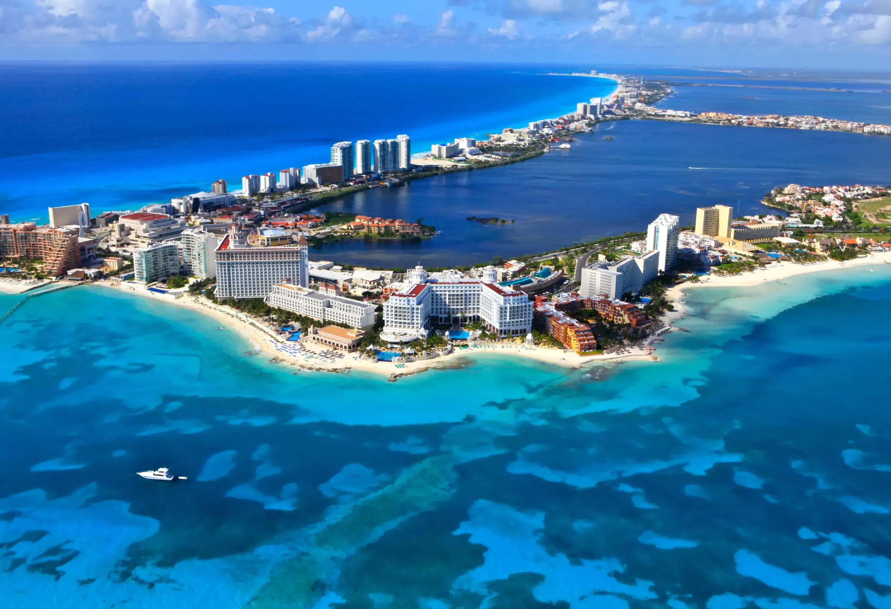 Cancun's unparalleled scenery including massive beachfront hotel structures bordered by azure waters.