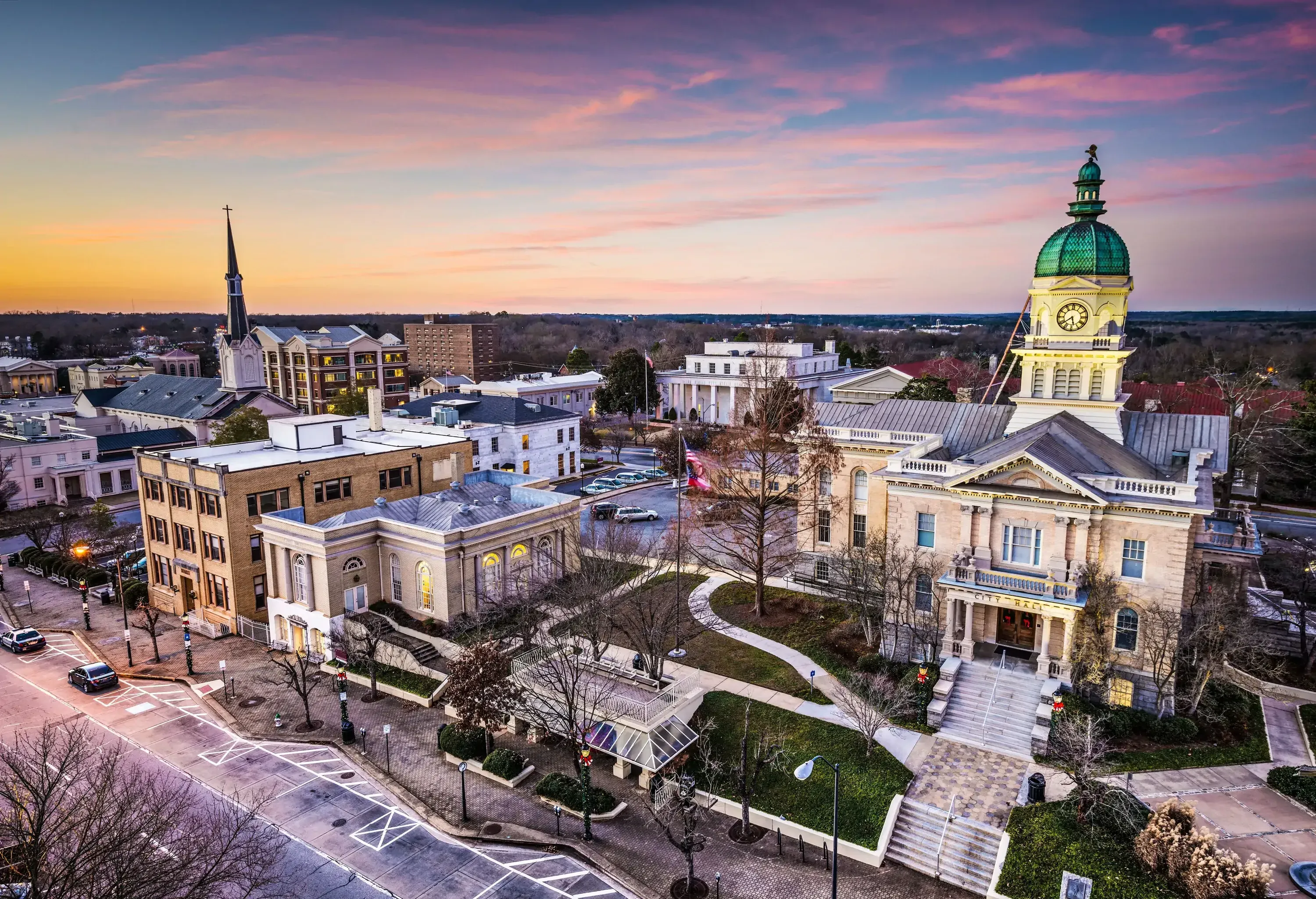 An urban area with a domed clock tower and other structures along a zig-zag concrete curb.