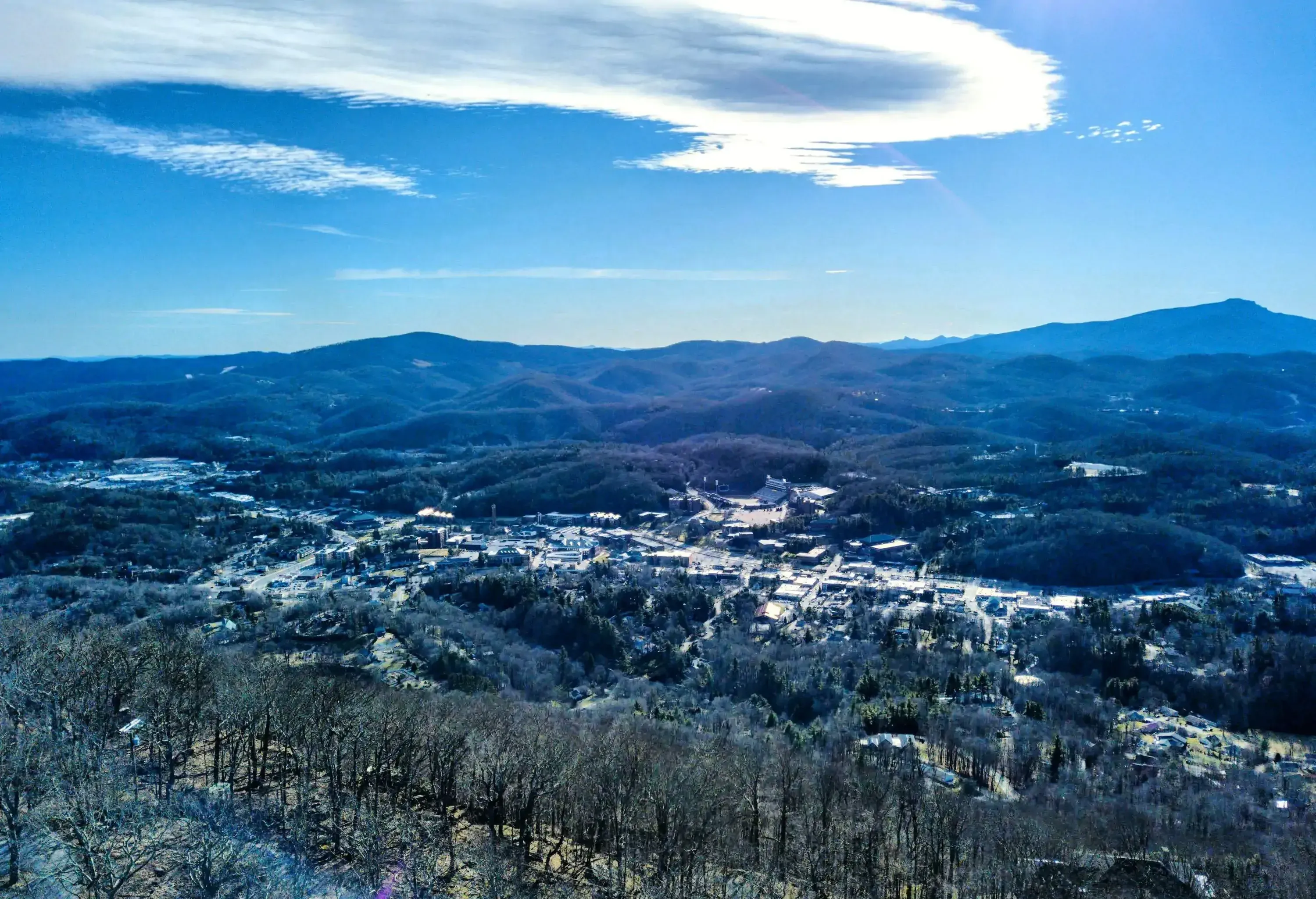 A charming town finds its cosy abode within the embrace of gently sloping wooded slopes.