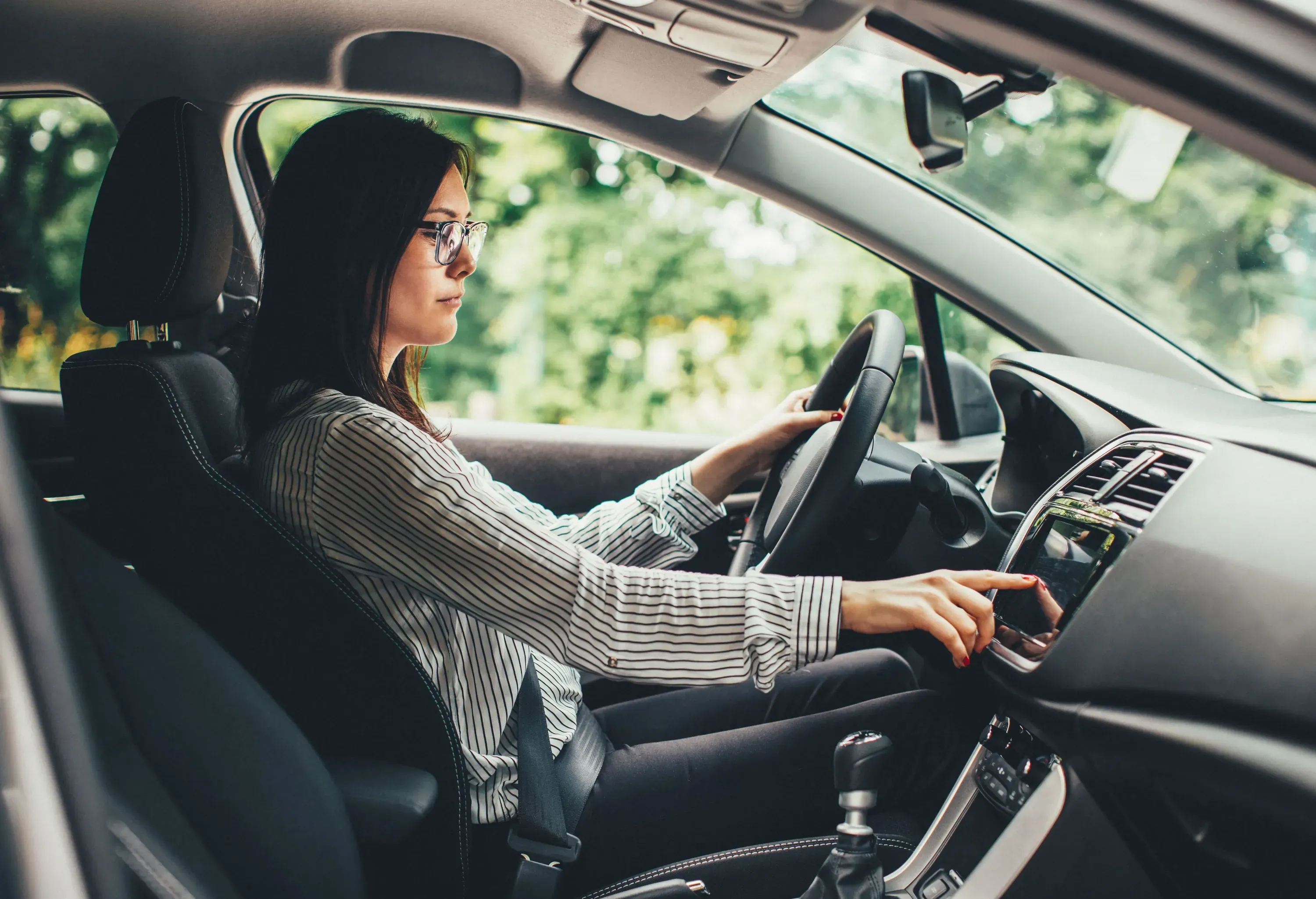 A woman in the driver's seat sets up the GPS.