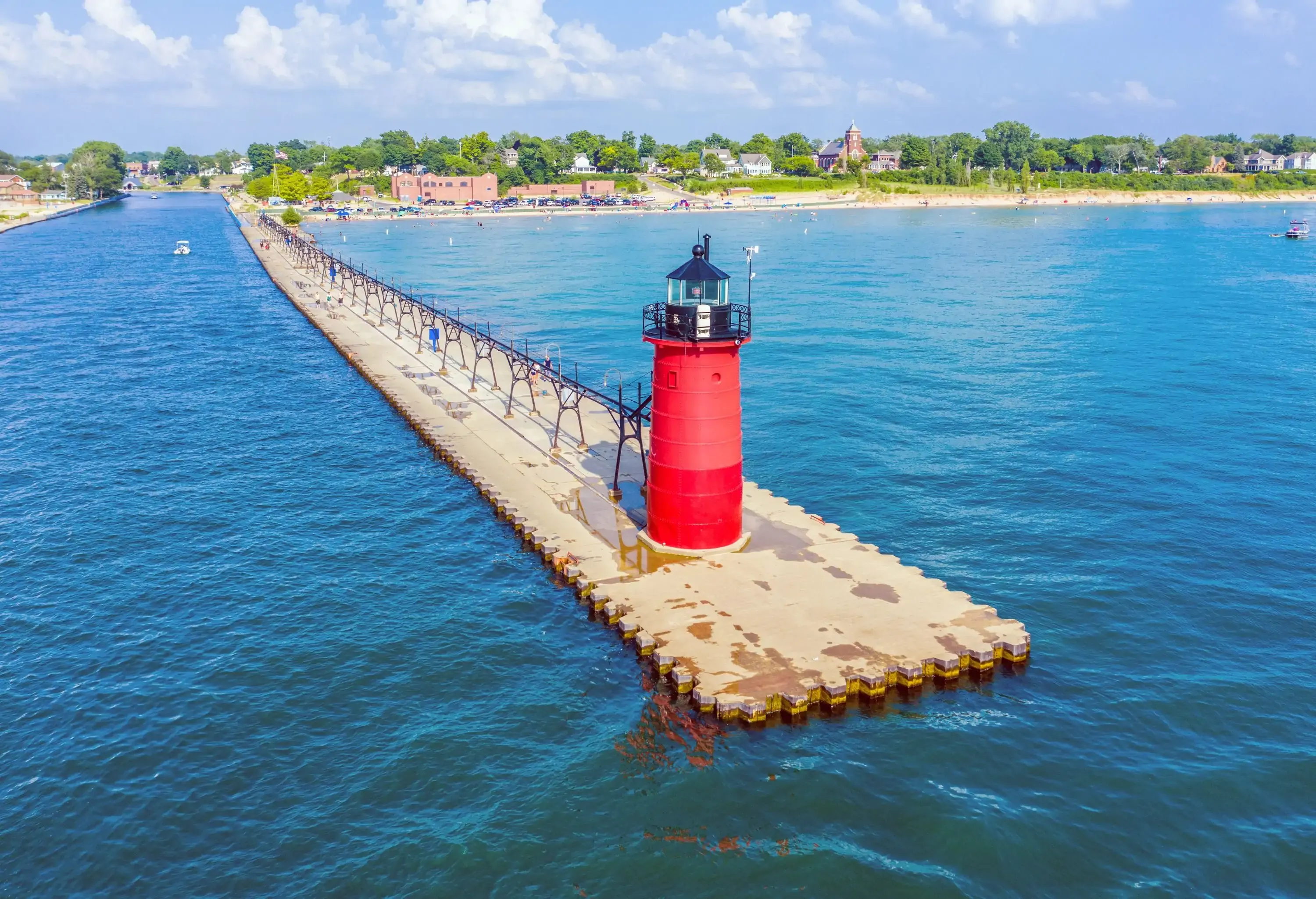 A long lakeside promenade with a red lighthouse.