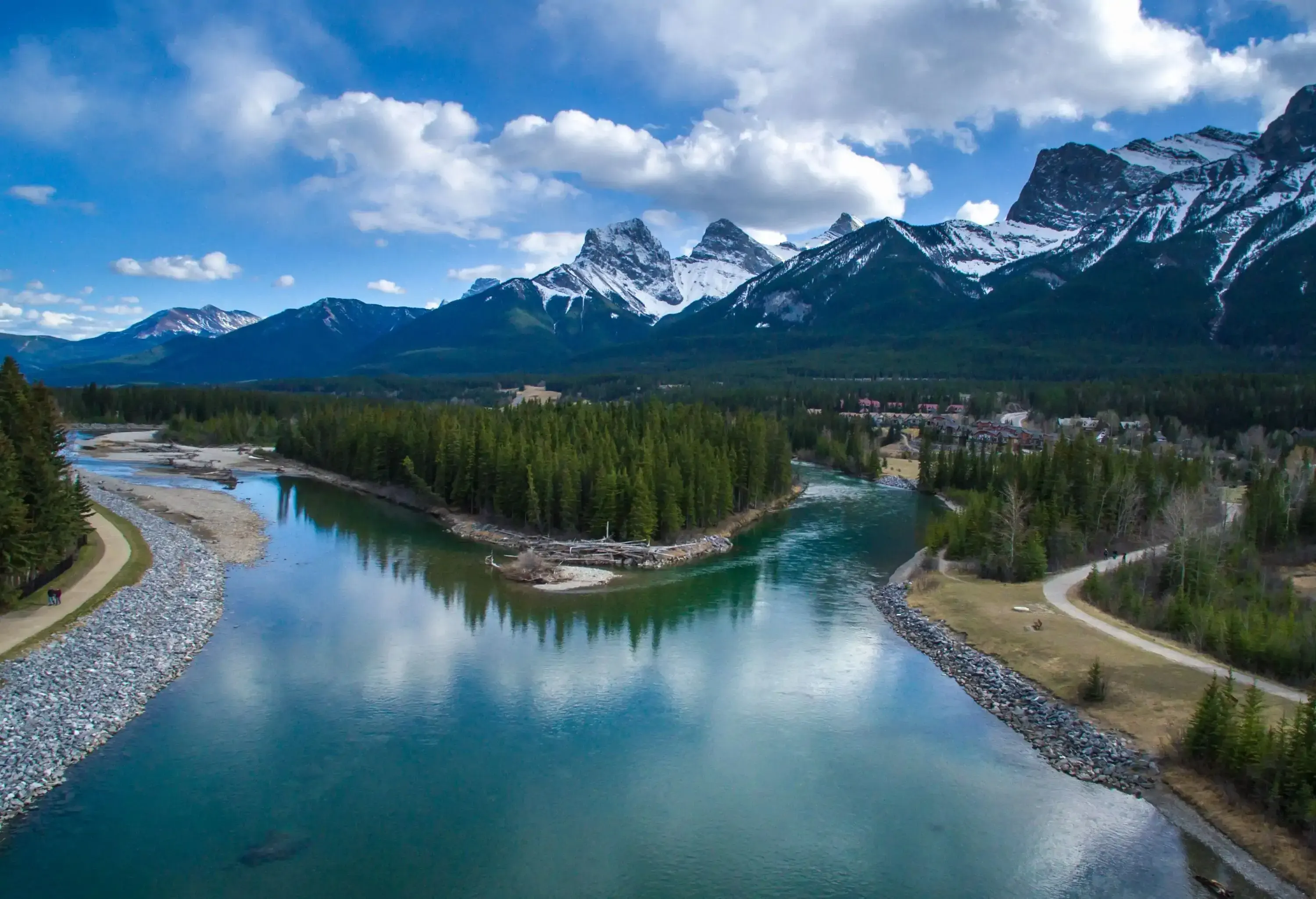 A river at the base of snow-capped mountains is split in two separate streams.