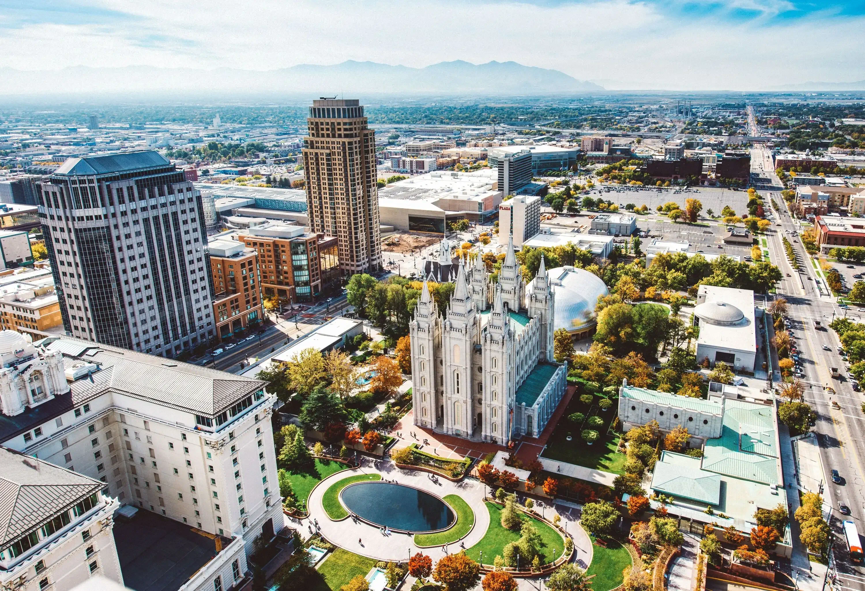 A public park with manicured gardens and a church in the heart of a city's downtown.