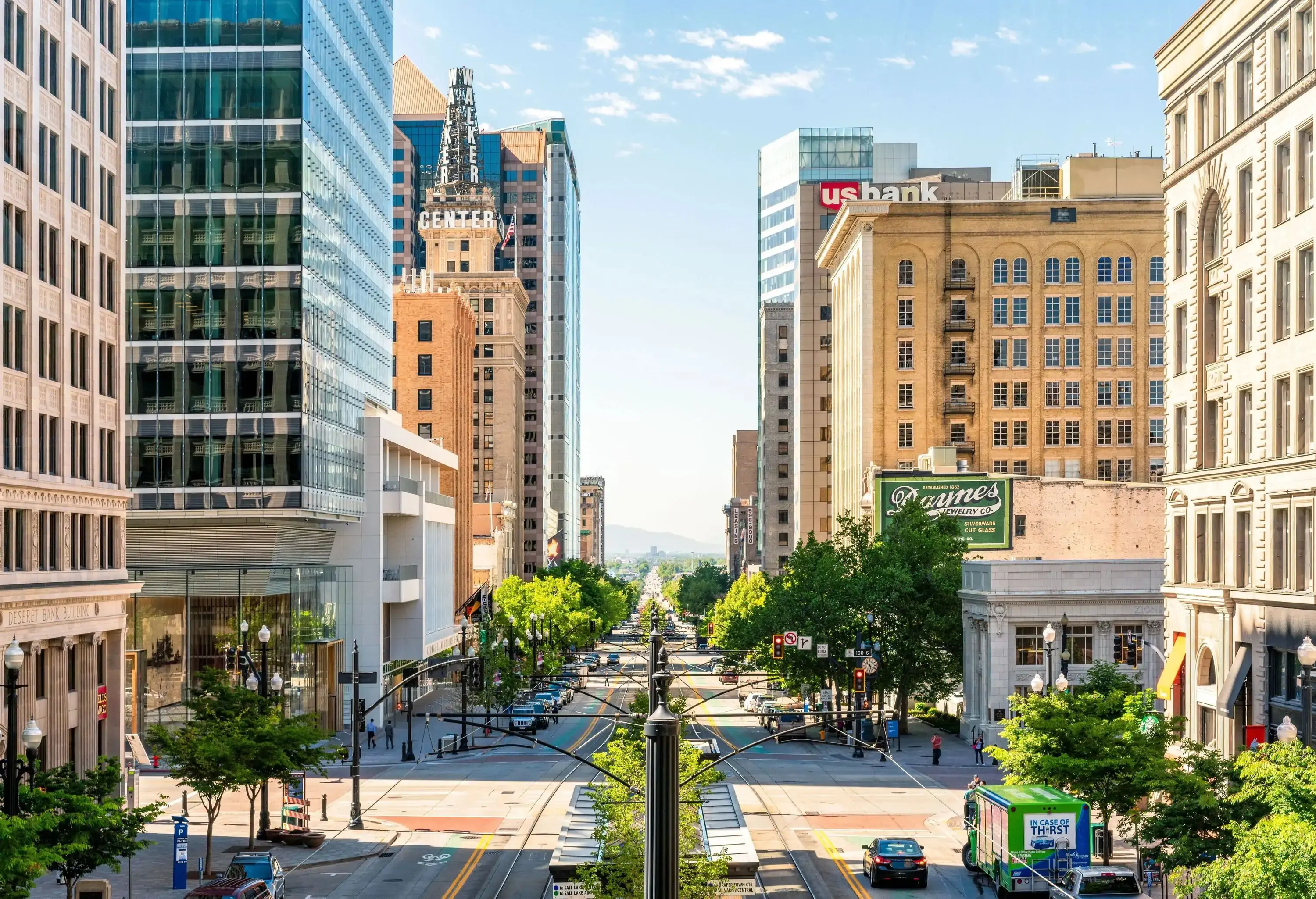 A straight street with the buildings and cars next to it is seen from a narrower angle as it extends far beyond the horizon.